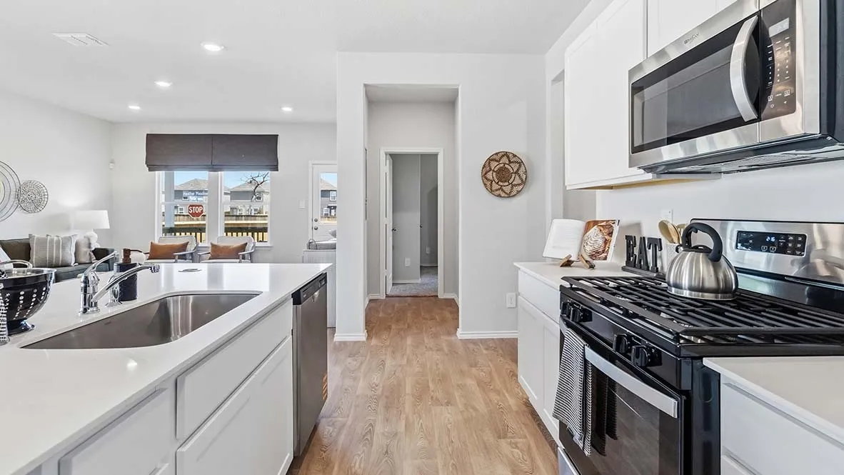 Kitchen featuring wood-finish flooring, white cabinetry, a kitchen island with an undermount sink, stainless steel appliances, and recessed lighting
