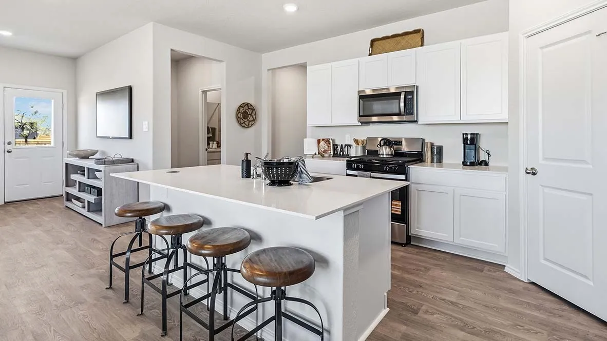 Kitchen featuring white cabinetry, stainless steel appliances, a center island with countertop seating, and wood-finish flooring