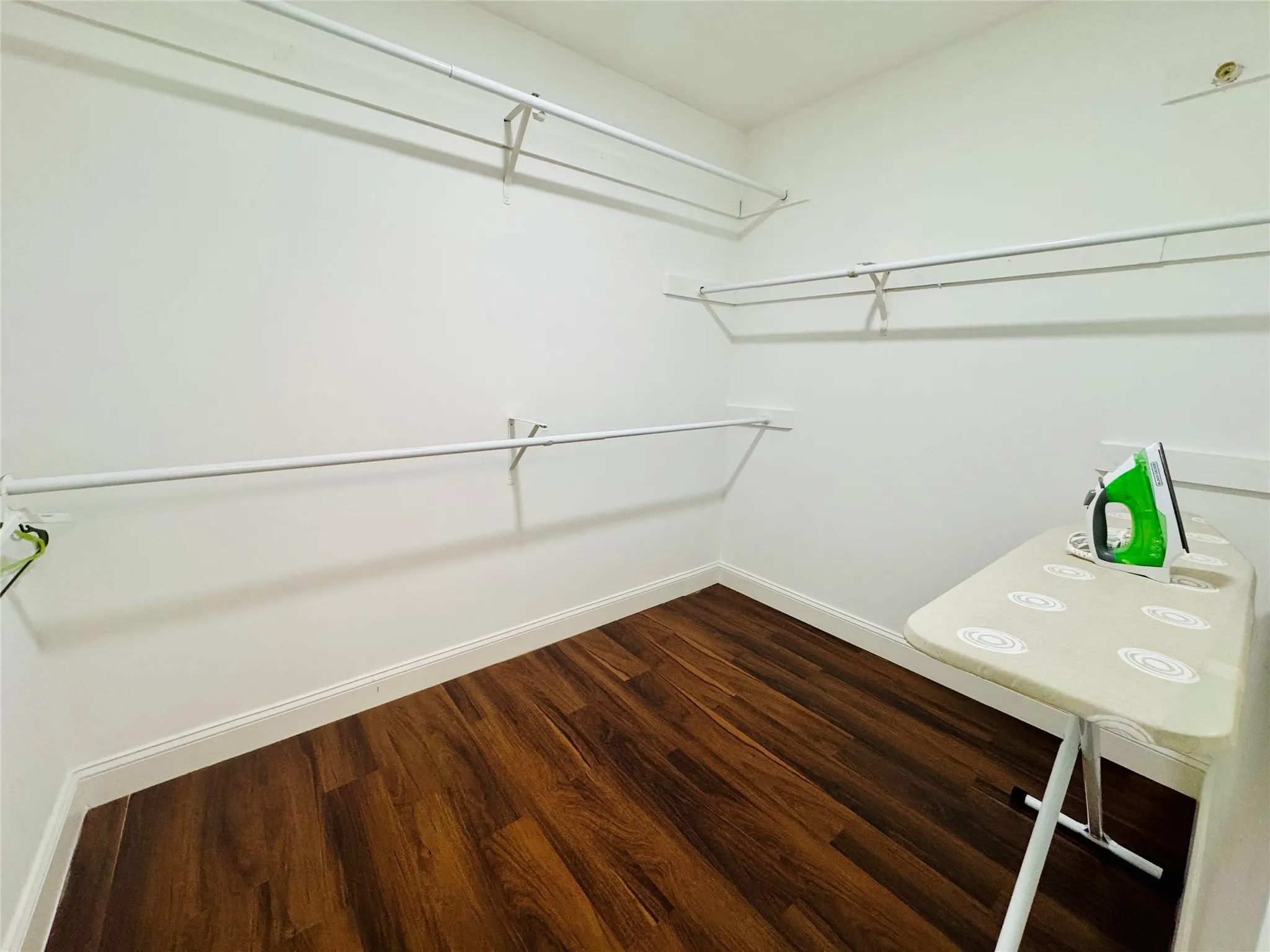 White walls with white trim, wood-finish flooring, and white wire shelving