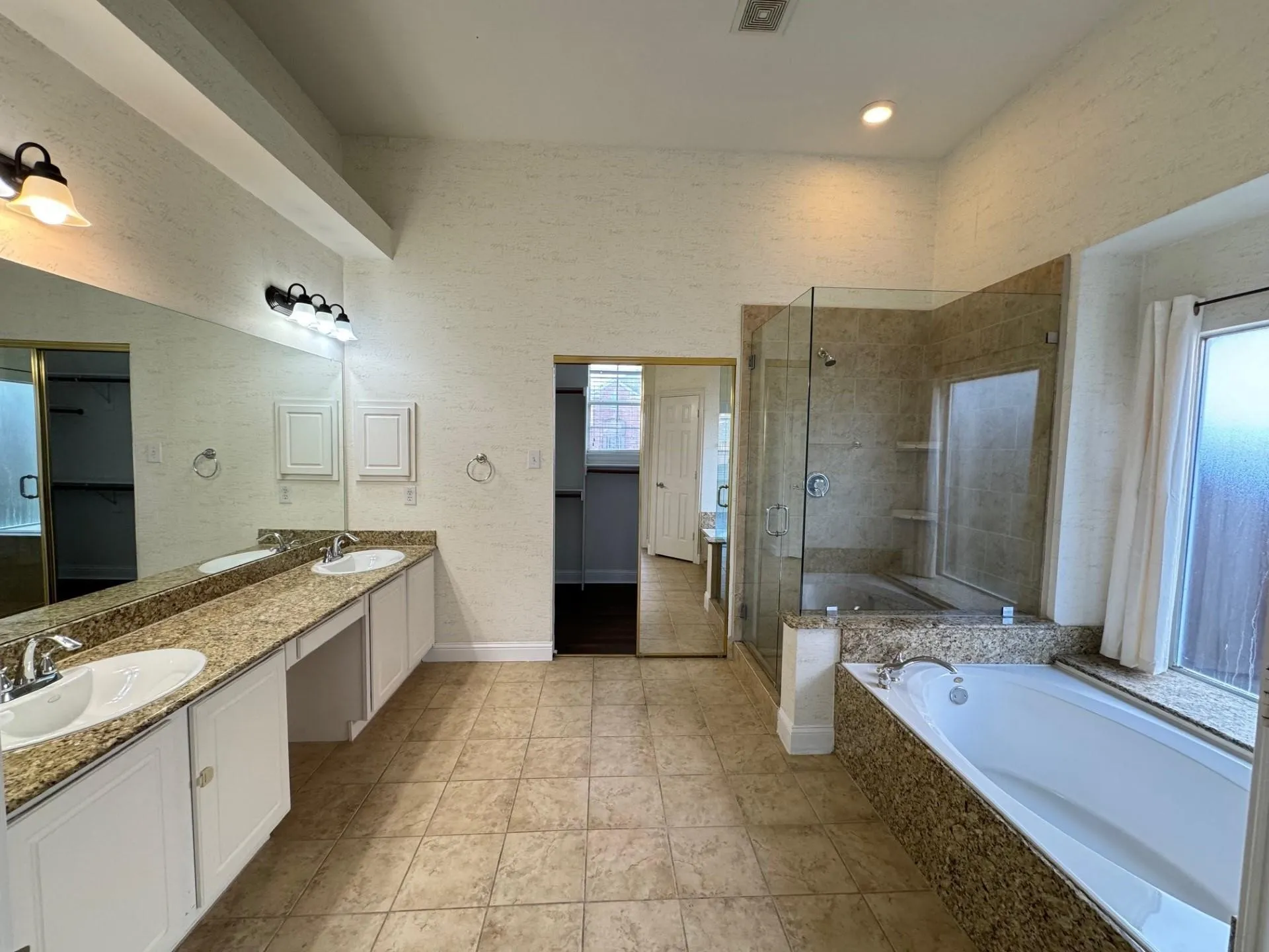 Dual vanity with integrated sinks, granite-look countertops, and white cabinetry