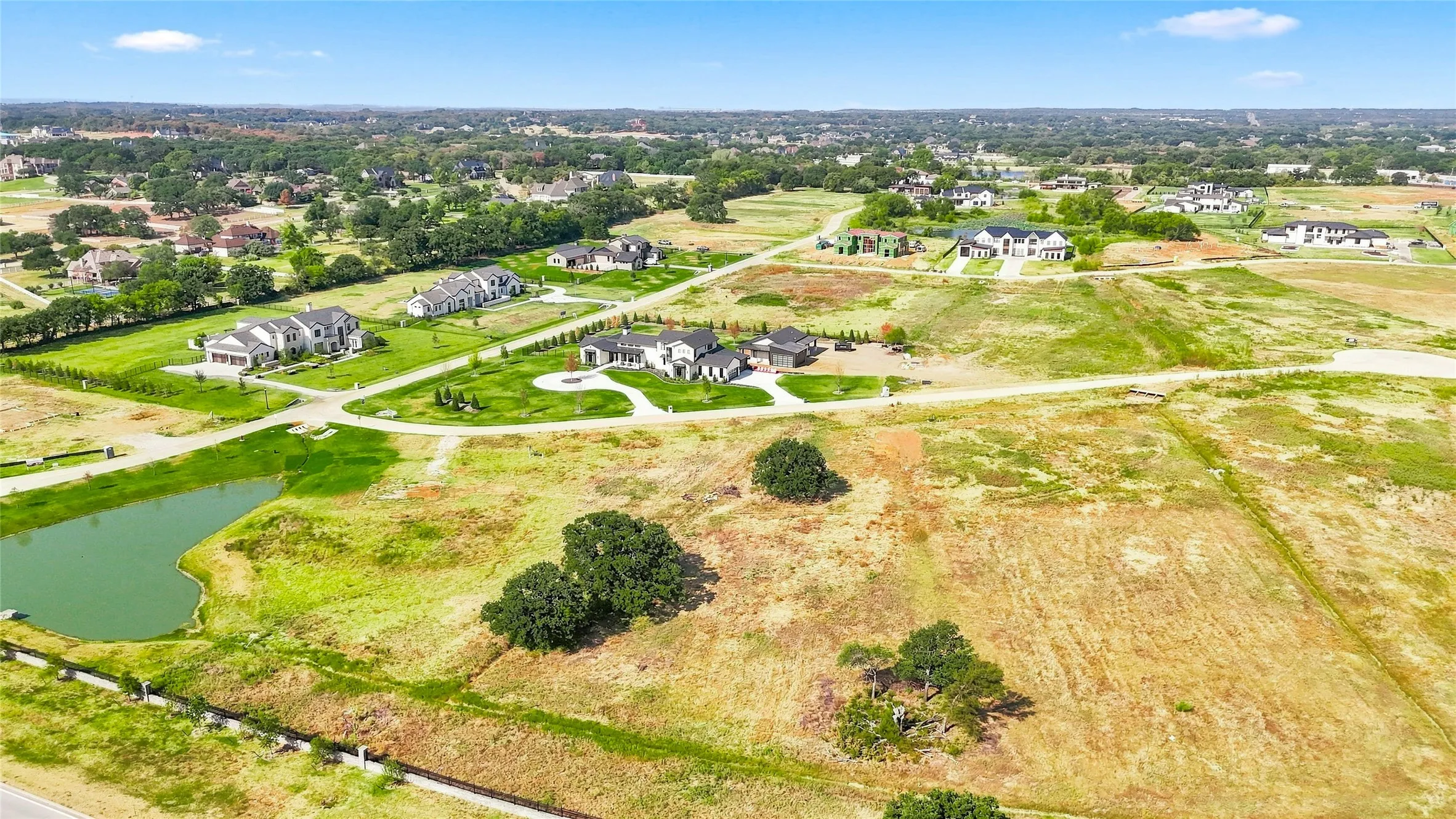 Expansive lot with a natural pond and mature trees, surrounded by residential properties