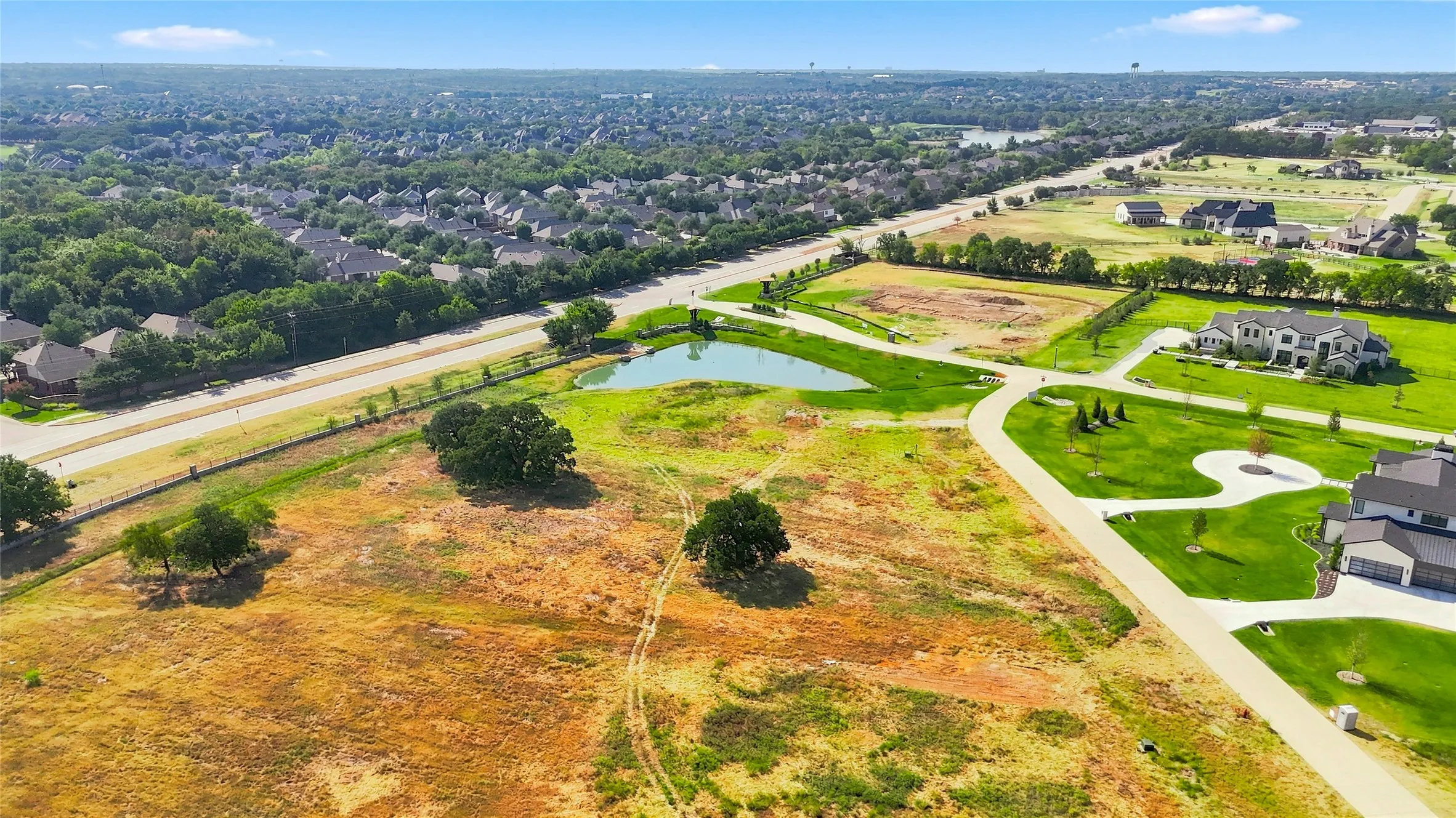 Expansive lot with a natural pond, mature trees, and paved road access