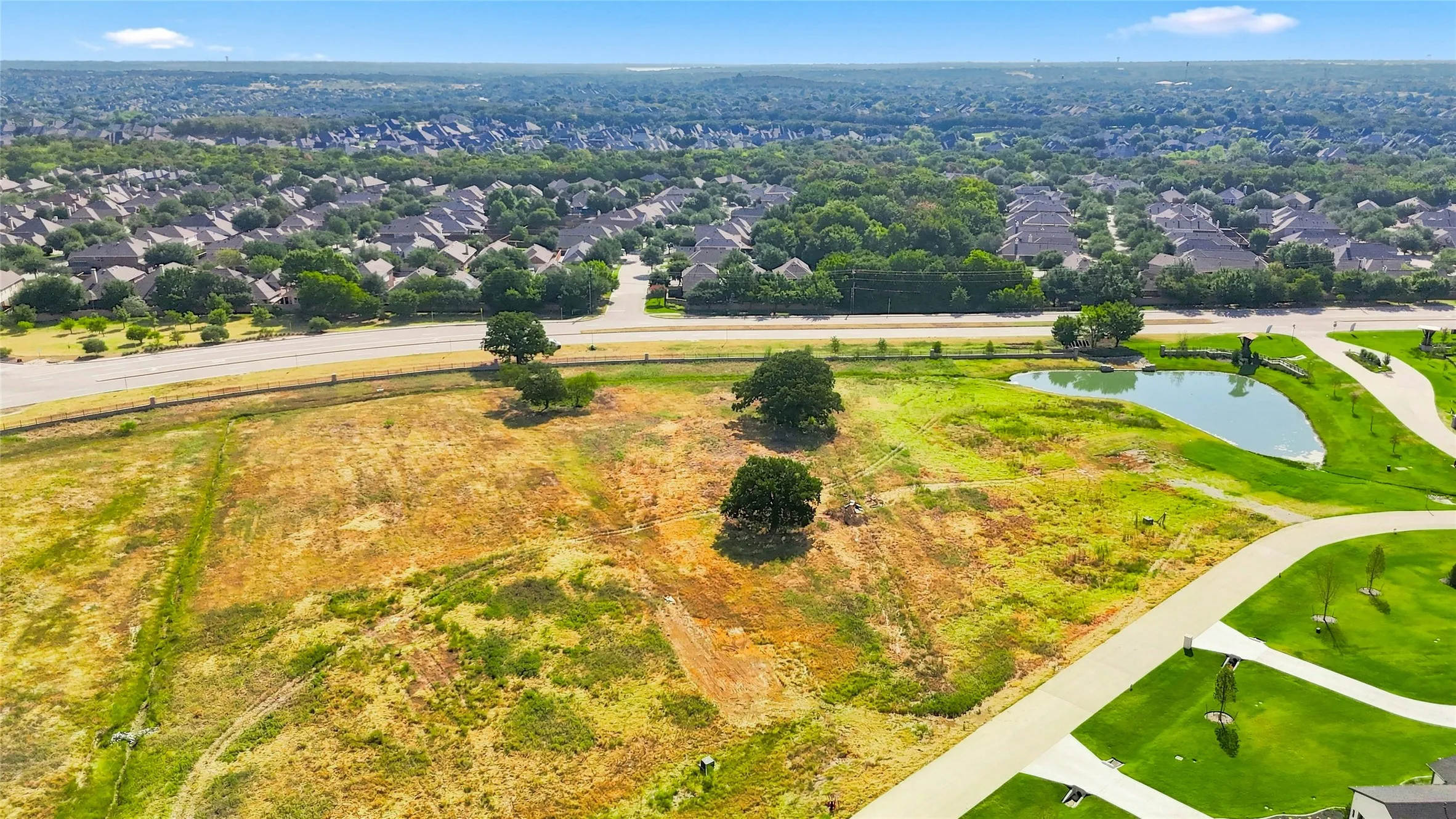 Expansive undeveloped parcel with a natural pond and mature trees