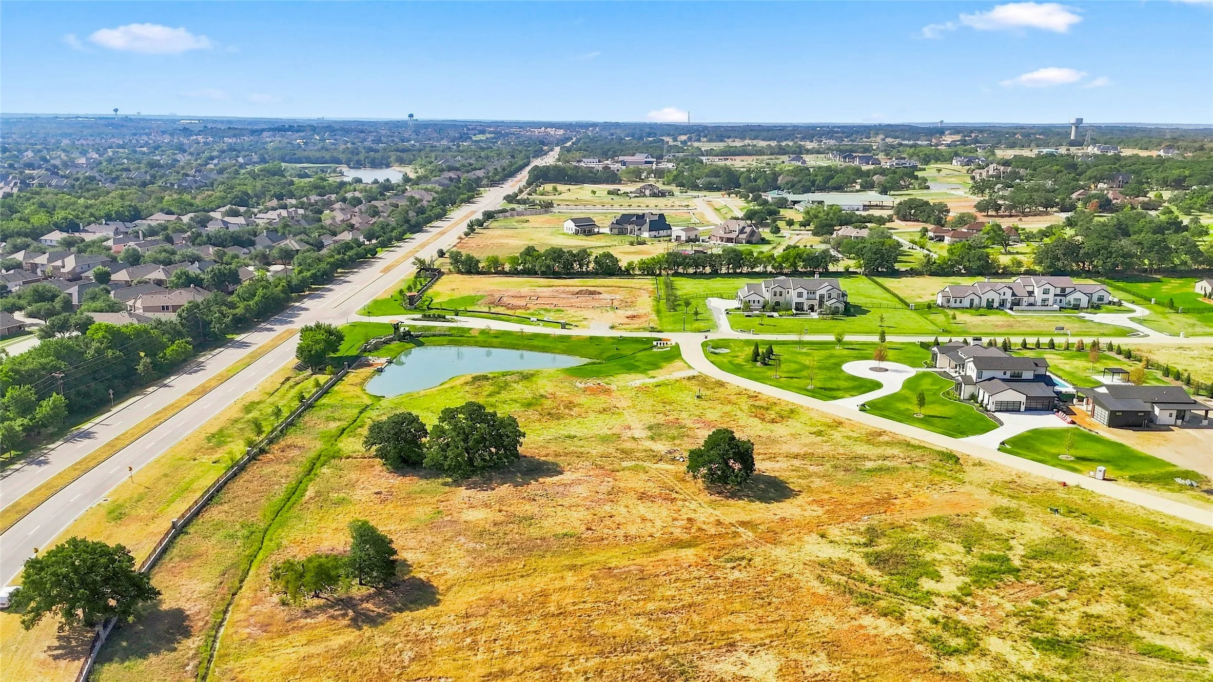 Expansive land parcel with a private pond, mature trees, and direct road access