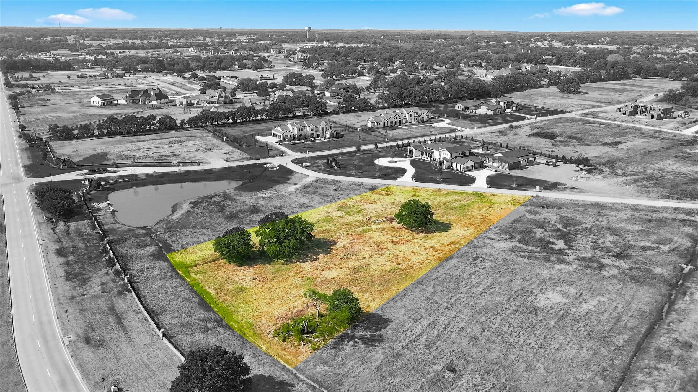 Expansive land parcel featuring mature trees and a natural water feature
