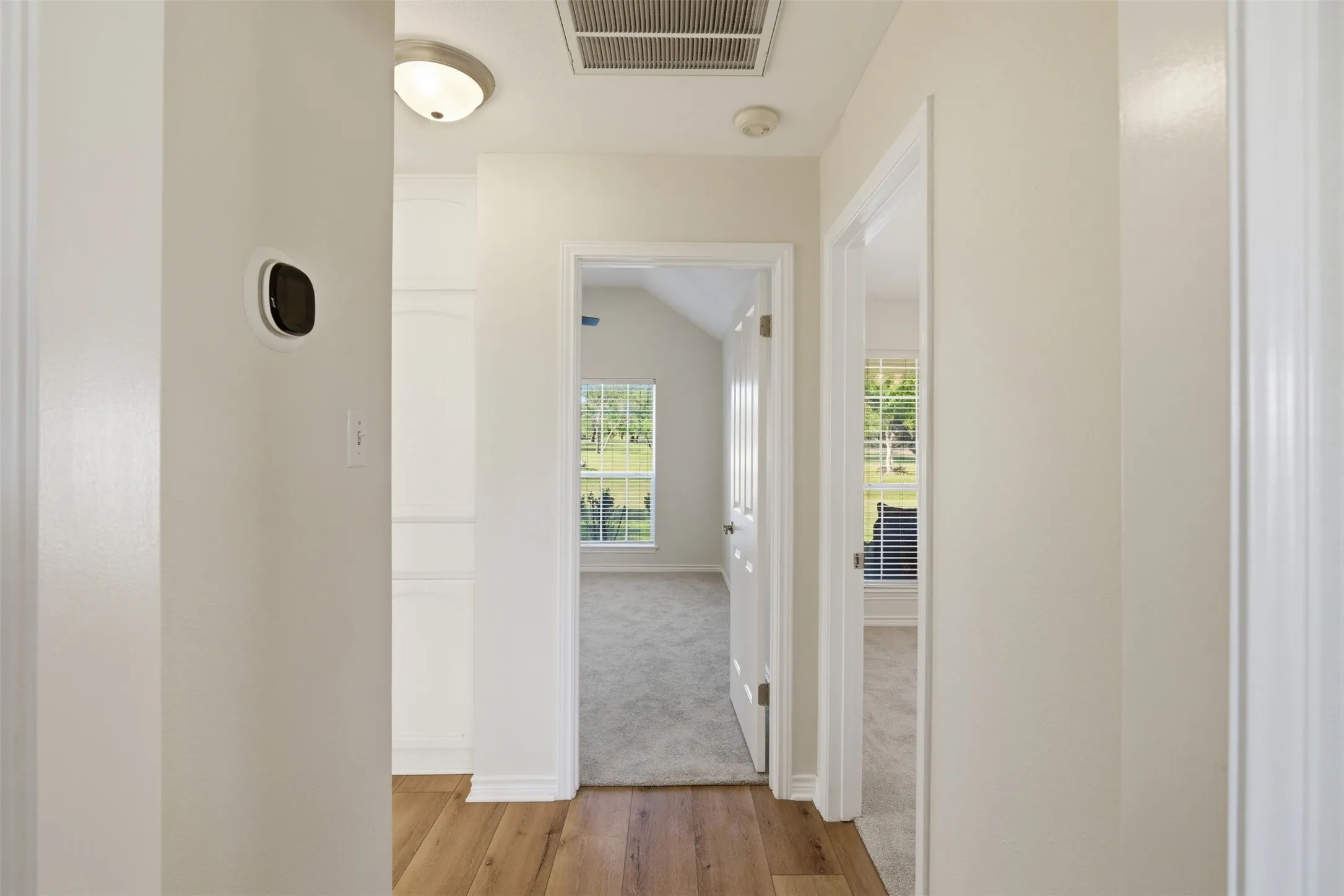 Wood-finish flooring leading to carpeted rooms