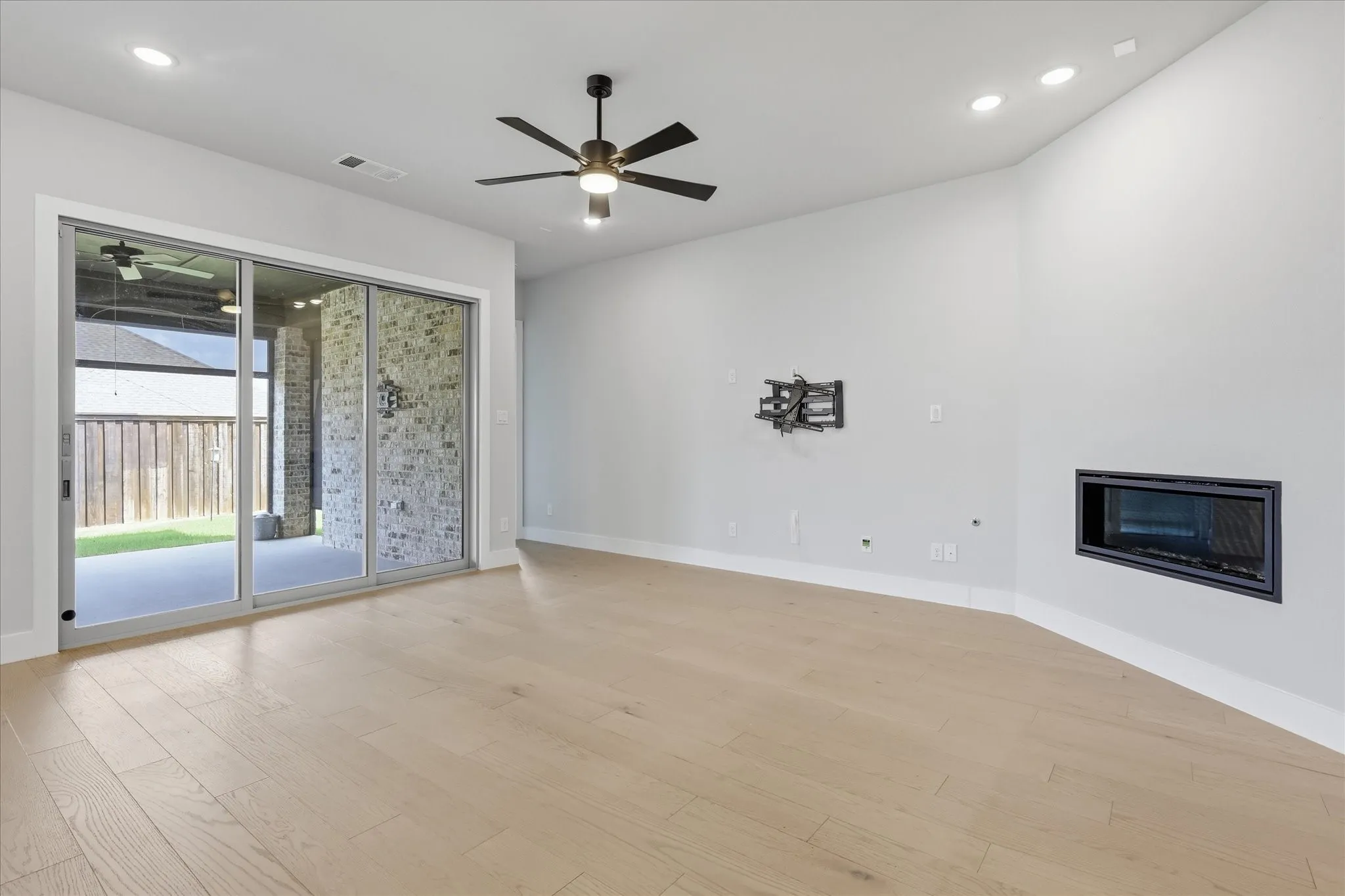 Bright room with light wood-finish flooring, recessed lighting, and a contemporary ceiling fan