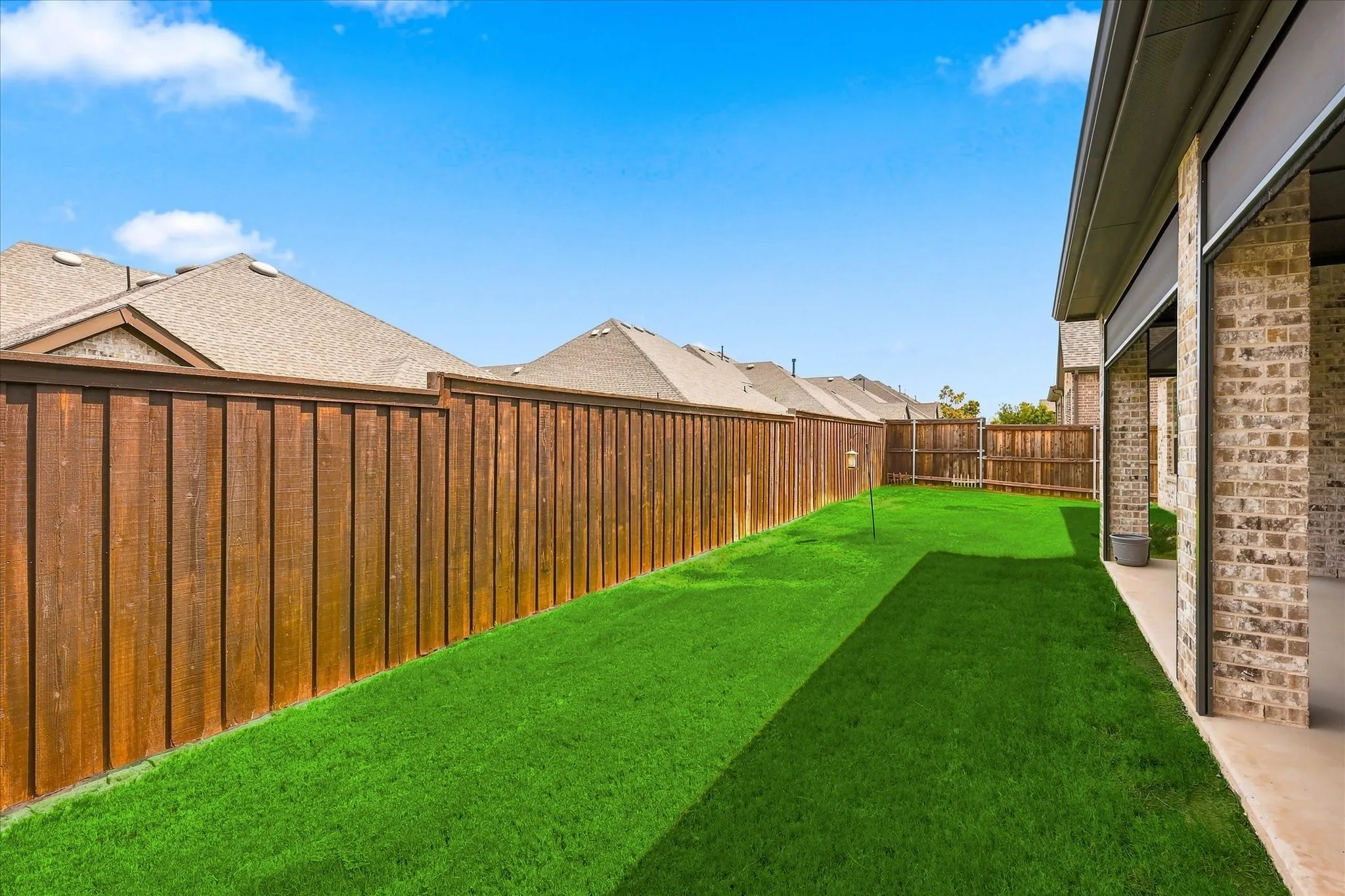 Expansive grass lawn with a wood privacy fence
