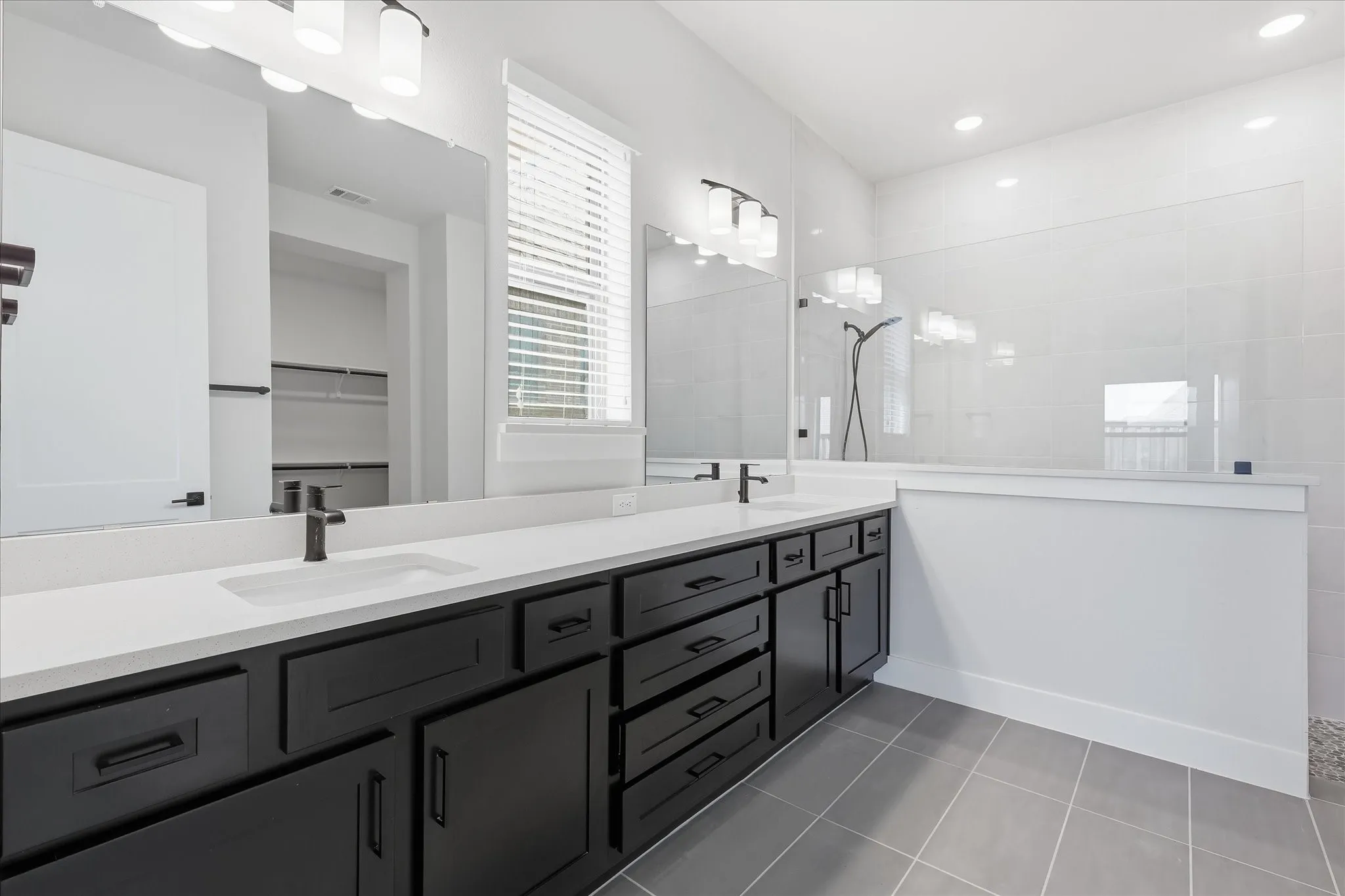 Dual vanities with matte black fixtures, white countertops, and dark wood​​‌​​​​‌​​‌‌​‌‌​​​‌‌​‌​‌​‌​​​‌​​ cabinetry