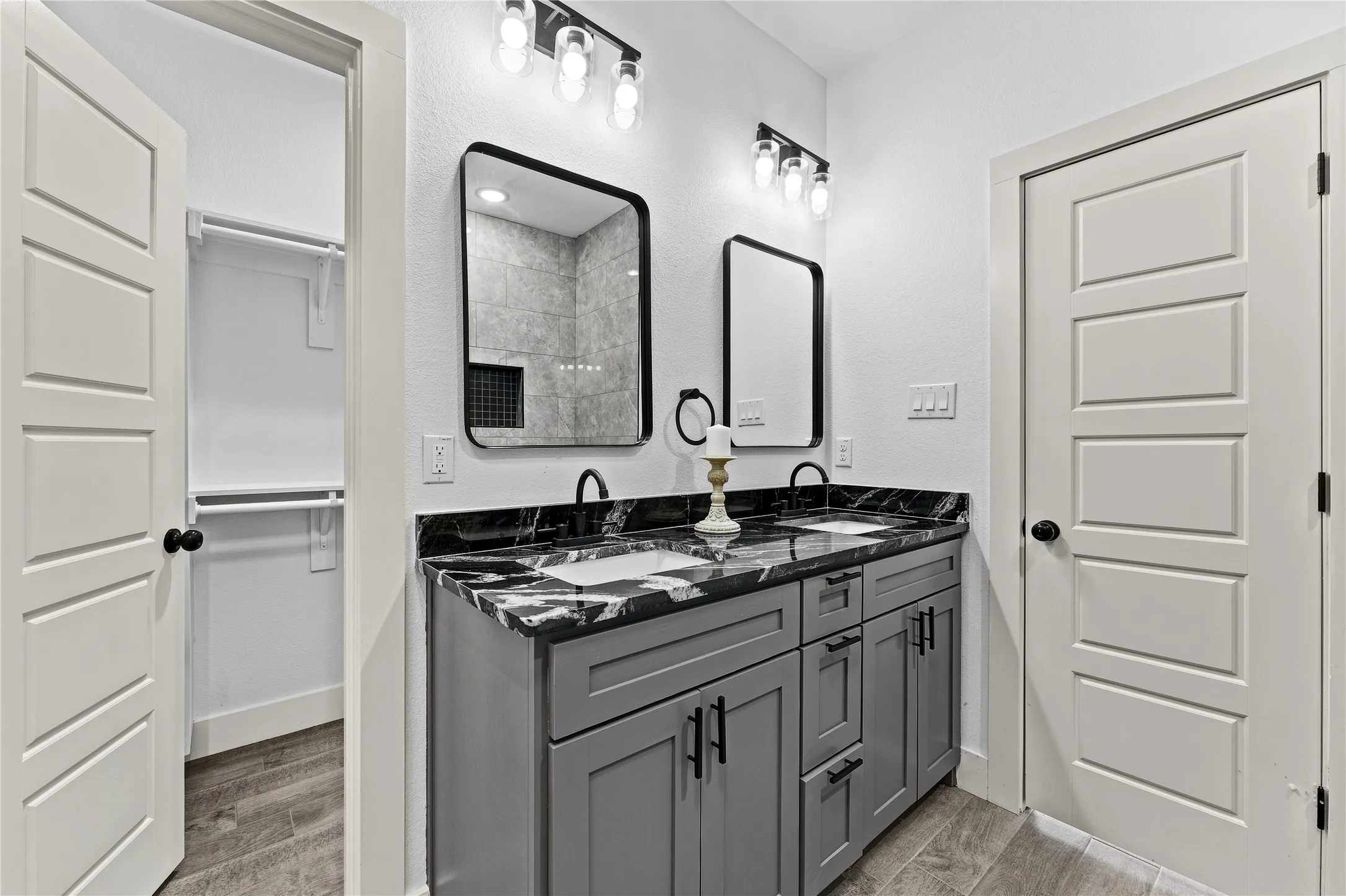 Dual vanity with dark patterned countertop, undermount sinks, and matte black fixtures