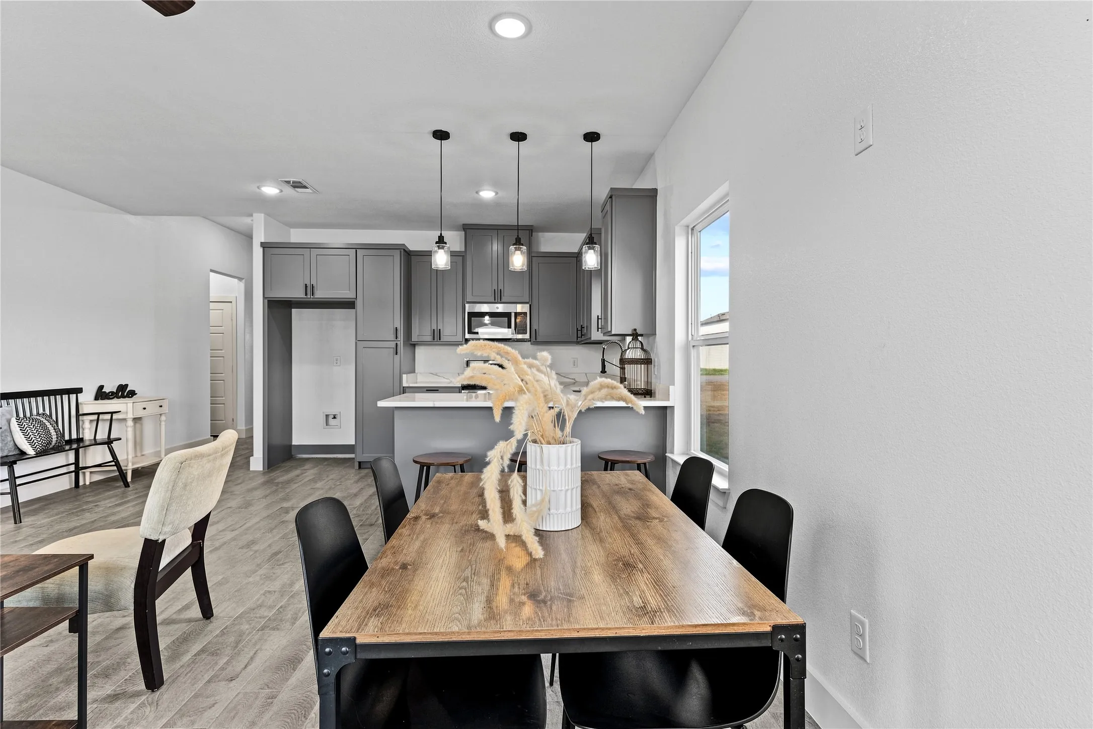 Open-concept living space with wood-finish flooring, recessed lighting, and a white color palette