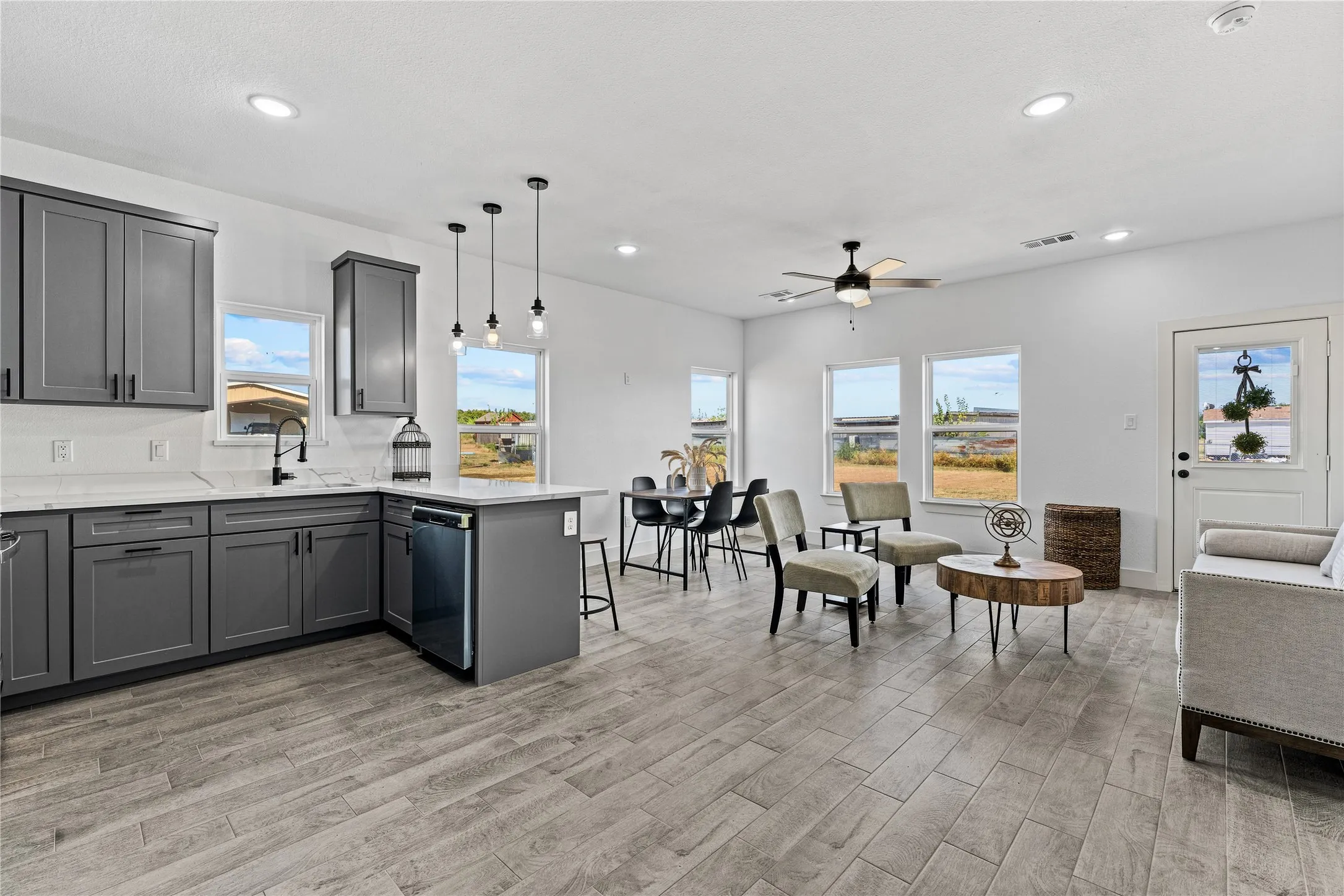 Open-concept living area featuring wood-finish flooring, recessed lighting, and a ceiling fan