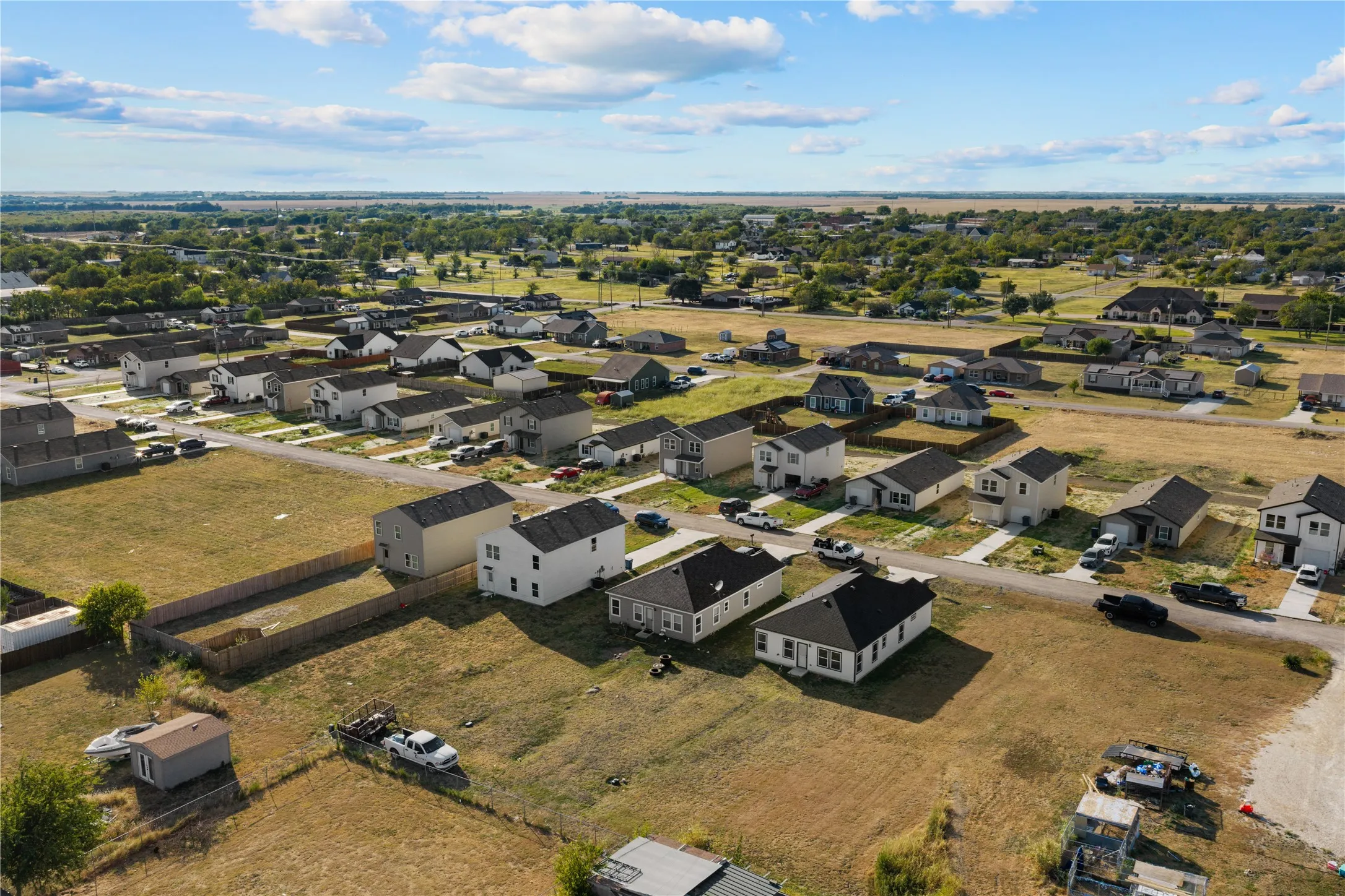 Aerial perspective of a developing residential area with multiple single-story and two-story homes