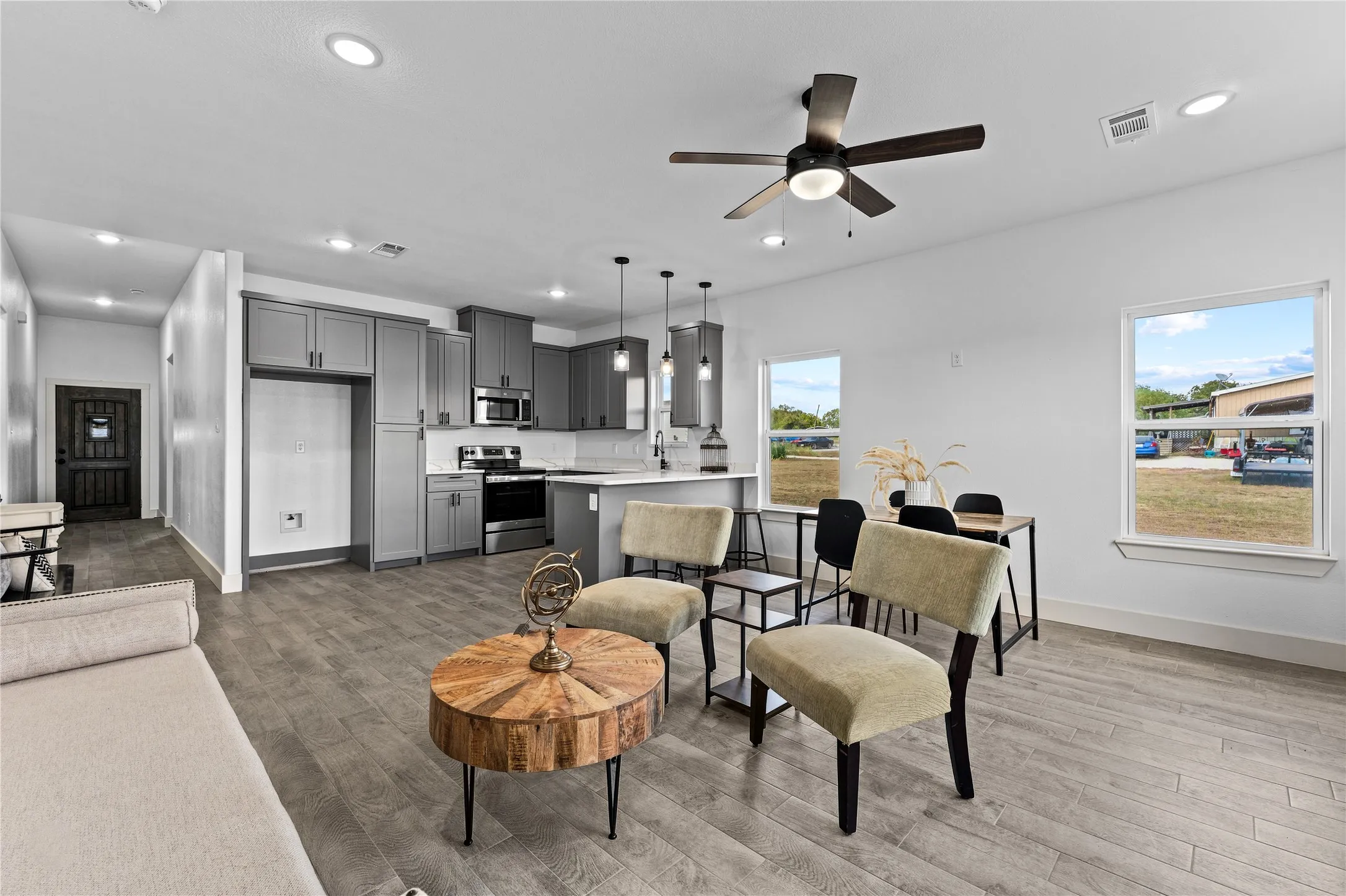 Open-concept living area featuring wood-finish flooring, recessed lighting, and a ceiling fan