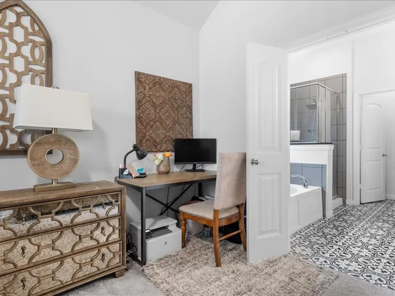 Built-in soaking tub with tile surround, glass-enclosed shower, patterned floor tile, and a paneled door