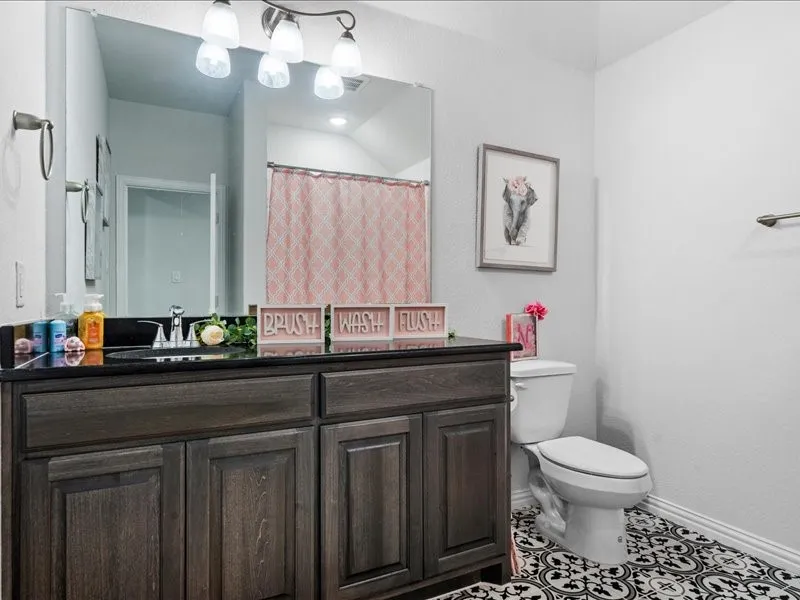 Dark wood-finish vanity with a black countertop