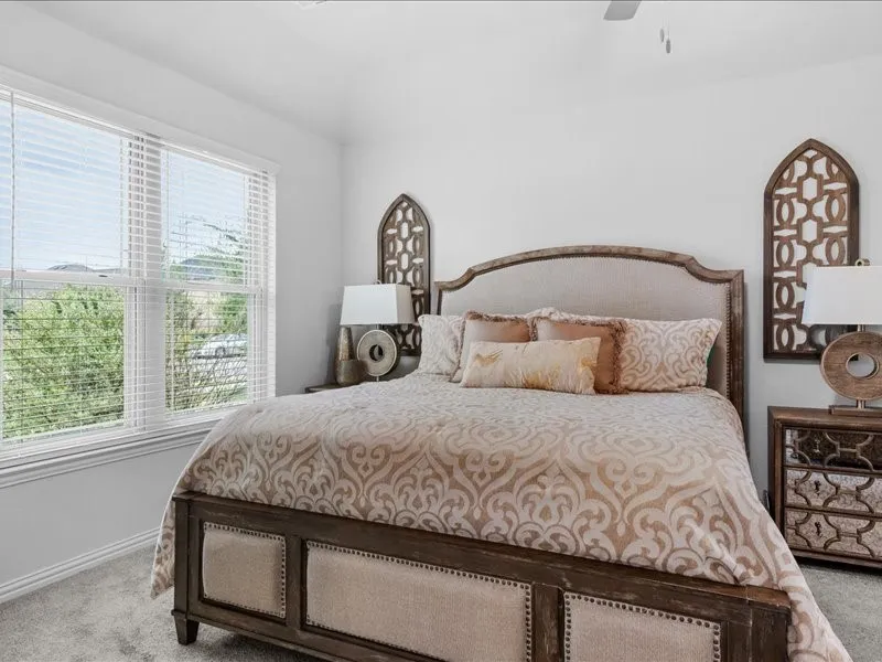 Vast window with white blinds, vaulted ceiling, and carpeted flooring