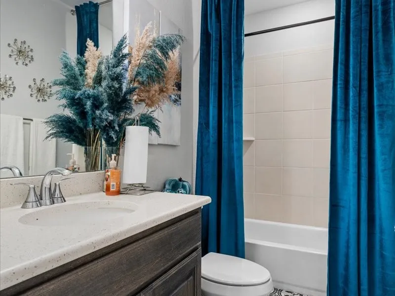 Vanity with integrated sink, chrome faucet, and dark wood-finish cabinetry