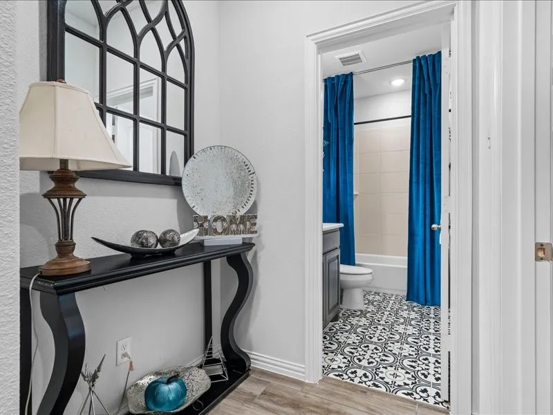 Wood-finish flooring, white walls, and a black console table