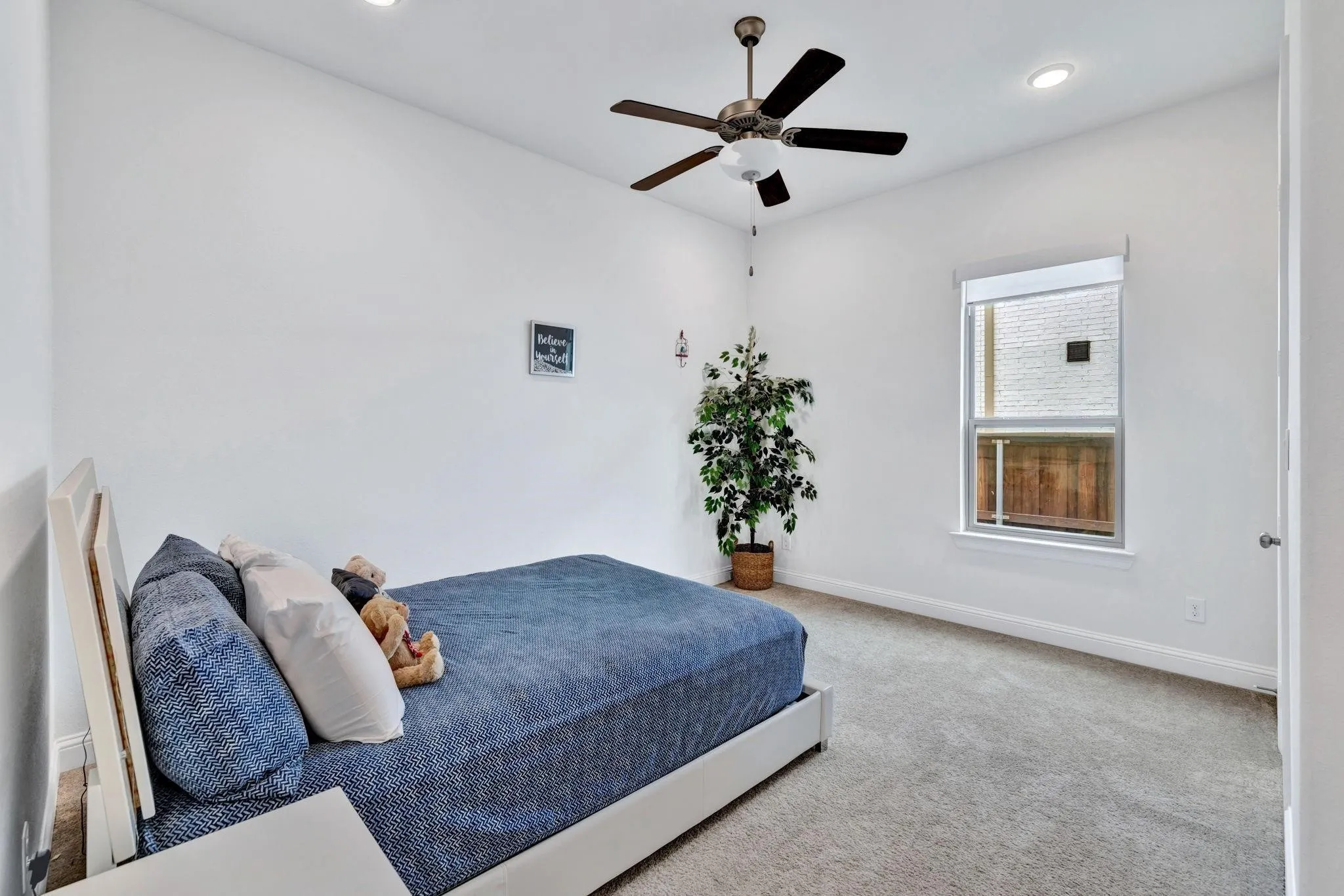 Recessed lighting, ceiling fan with light fixture, single window with roller shade, and light gray carpeted flooring