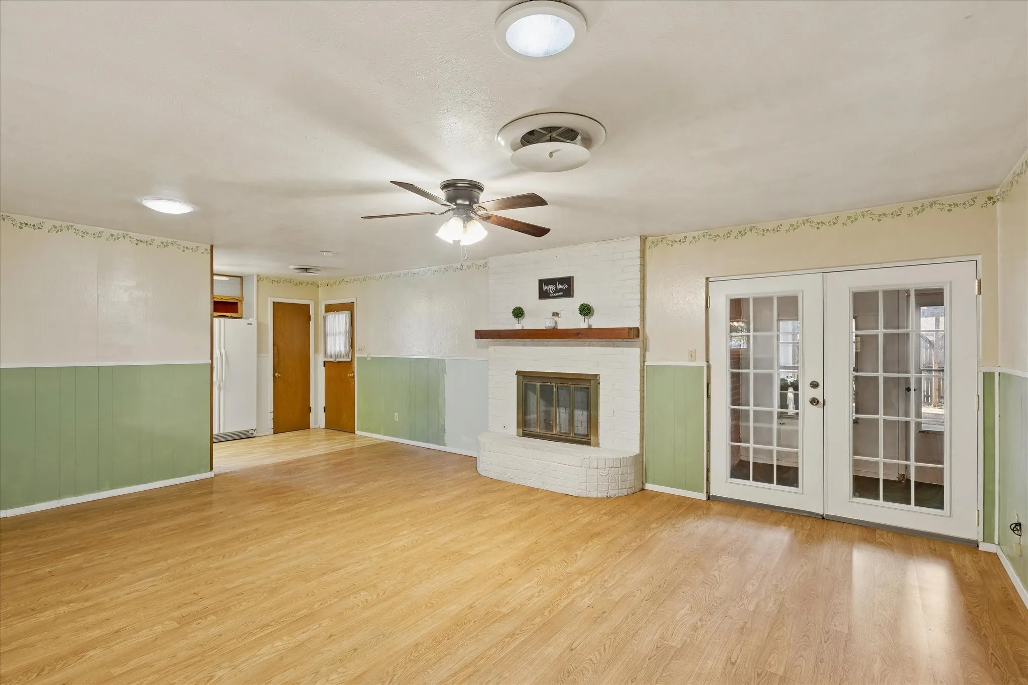 Living Room with Brick Fireplace & Frech Doors leading to closed in patio