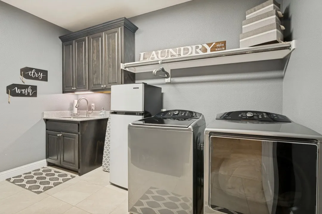 Built-in cabinetry with under-cabinet lighting, a utility sink with a high-arc faucet, and tiled flooring