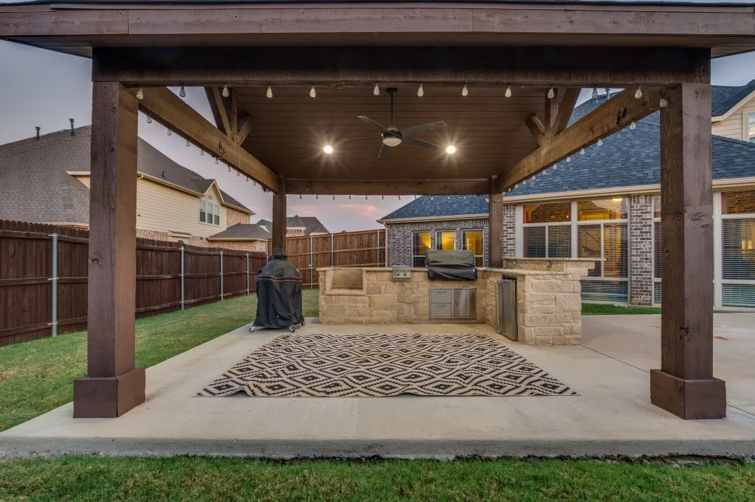 Covered patio with substantial wood beam construction, recessed lighting, and stamped concrete flooring