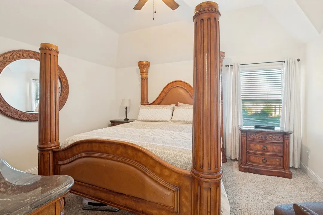 Vaulted ceiling, ceiling fan, window with blinds, and carpeted flooring