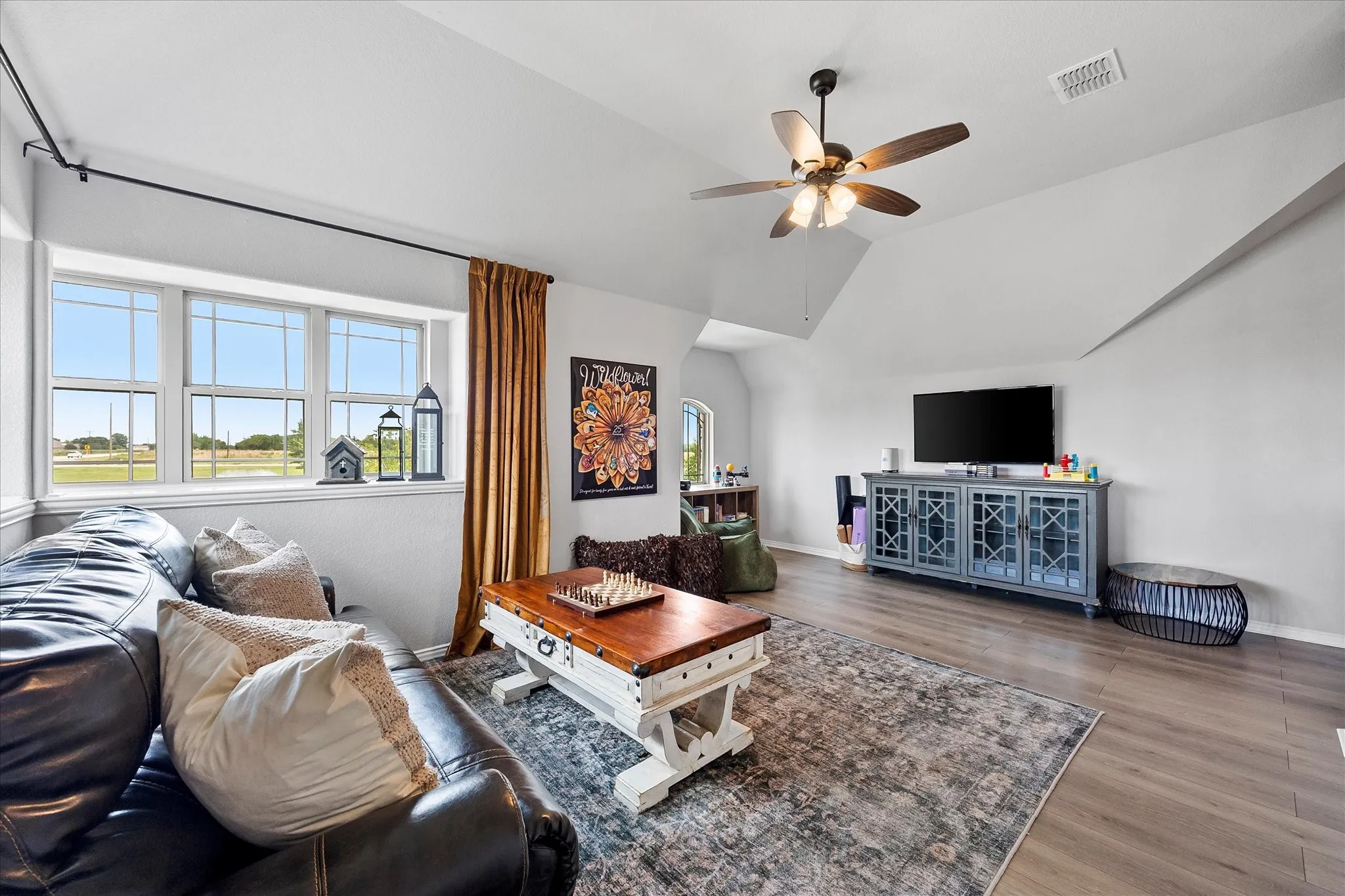 Game room featuring vaulted ceilings, wood-finish flooring, and multiple large windows