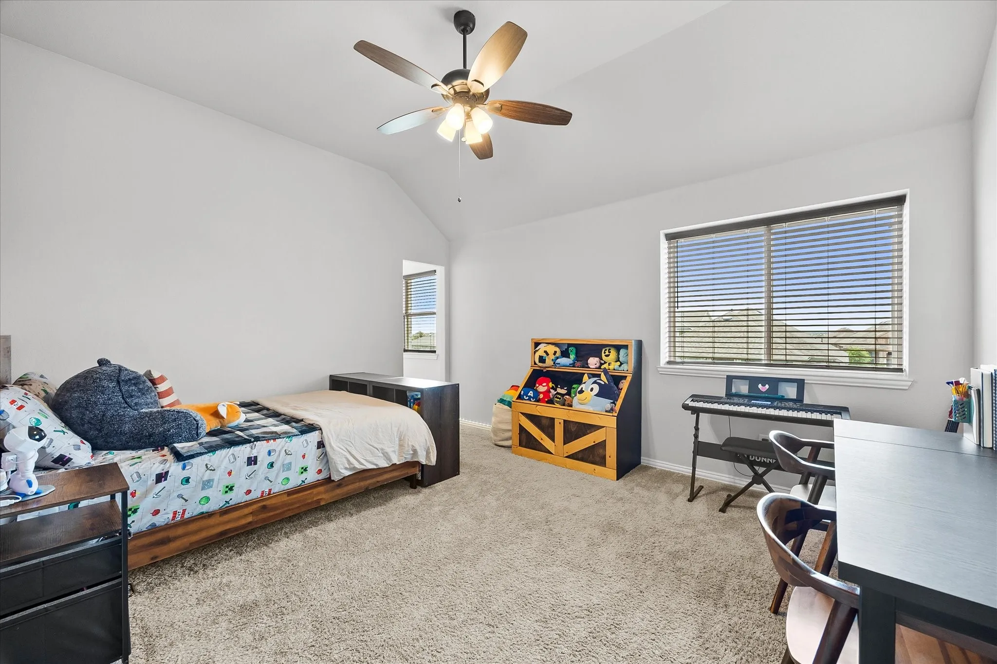 Spacious bedroom featuring light-colored walls and plush carpet flooring