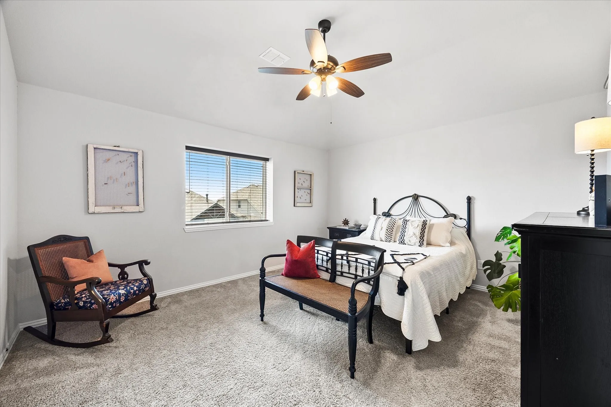 Carpeted bedroom featuring a ceiling fan with light fixture, a window with blinds, and white painted walls