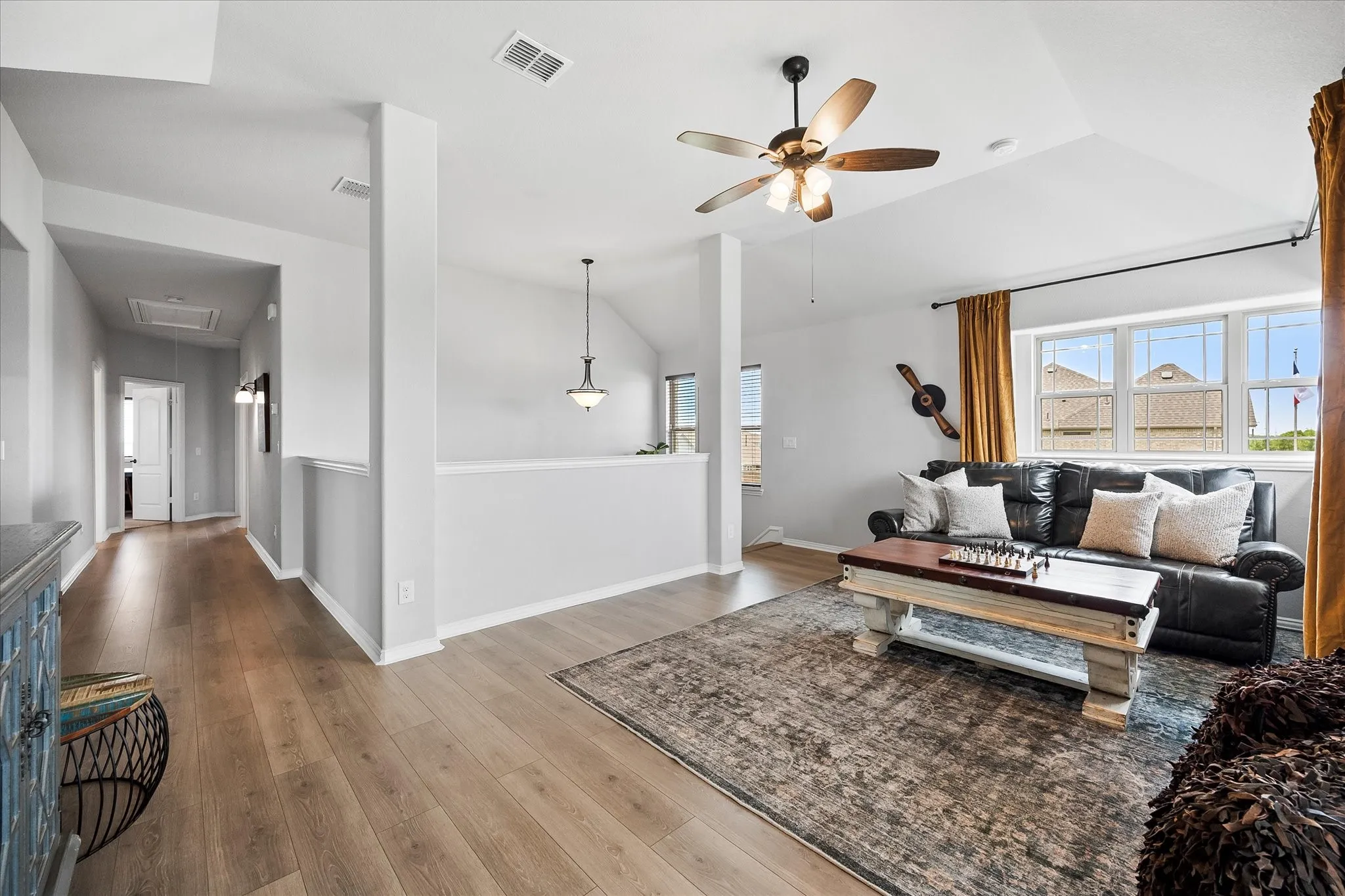 Game room area featuring wood-finish flooring, vaulted ceilings, and a contemporary ceiling fan