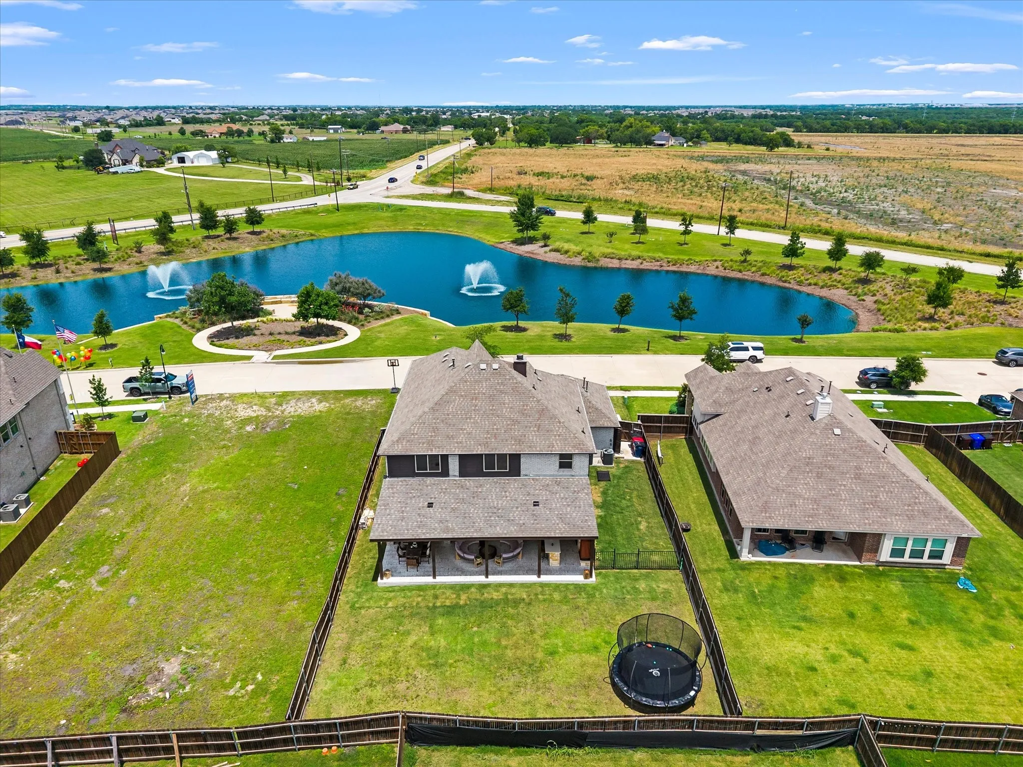 Two-story home featuring a covered back patio and a fenced backyard with a grass lawn