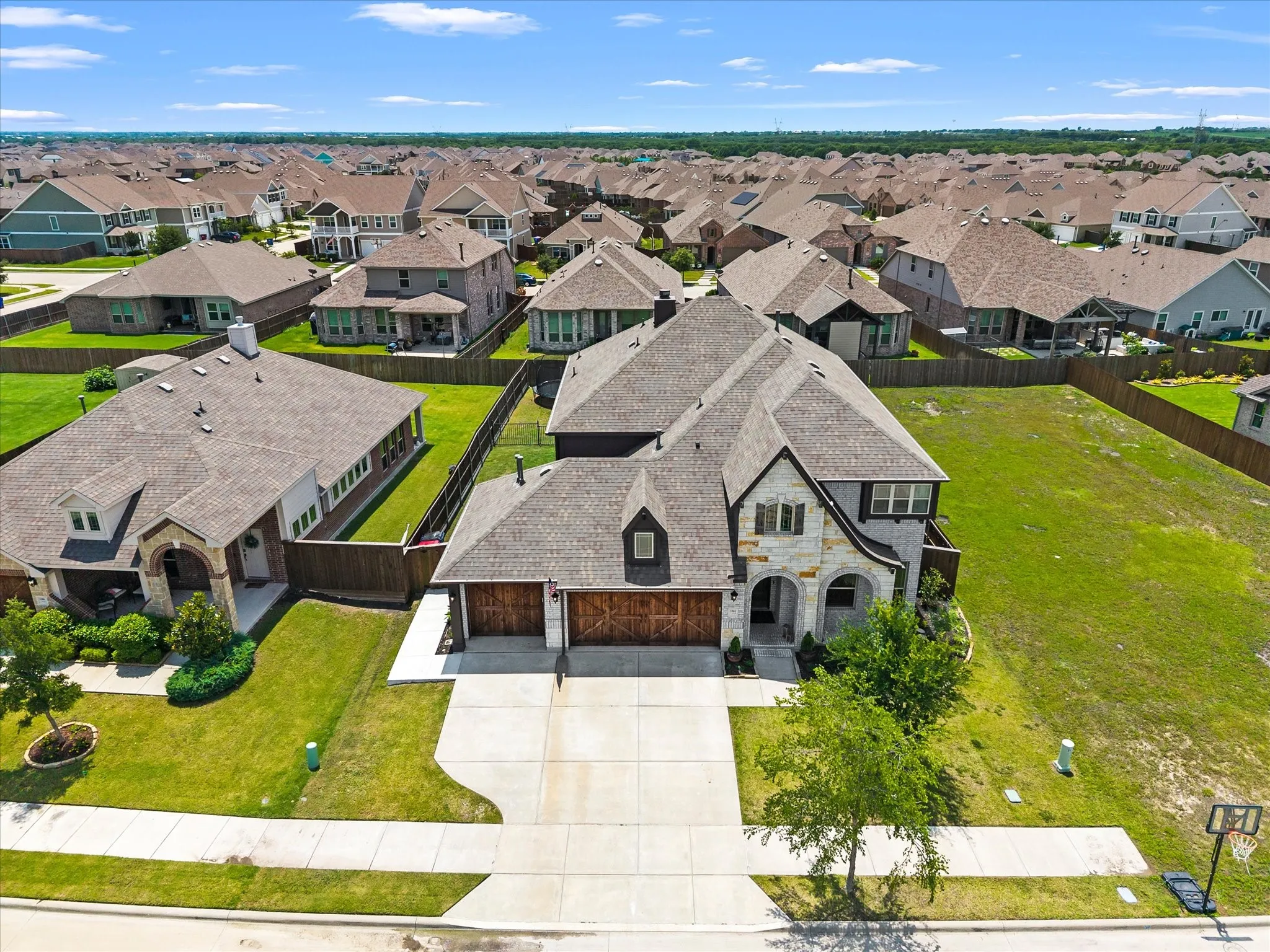 Two-story residence featuring a stone and siding exterior, a multi-gabled roofline, and a concrete driveway