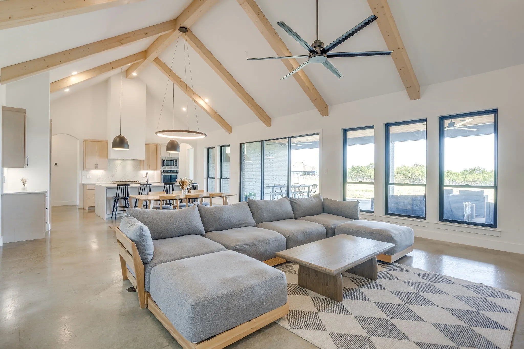  The great room is a large space featuring a cathedral ceiling, a wall of windows, exposed beams and built ins anchored by the floor to ceiling fireplace.