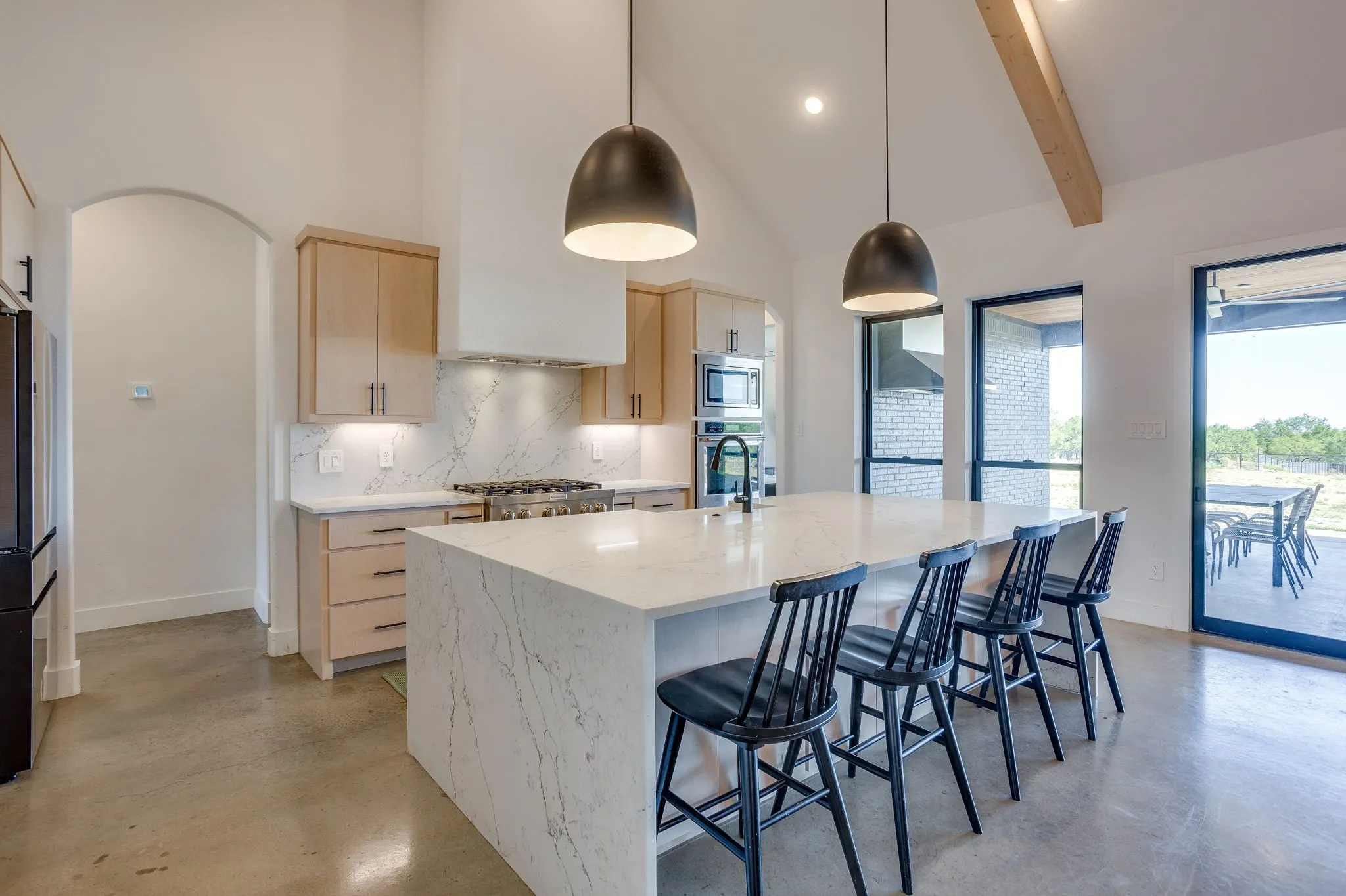 The gorgeous kitchen features an abundance of counter and cabinet space, quartz countertops, an oversized island with farm sink and Kitchen Aid appliances.