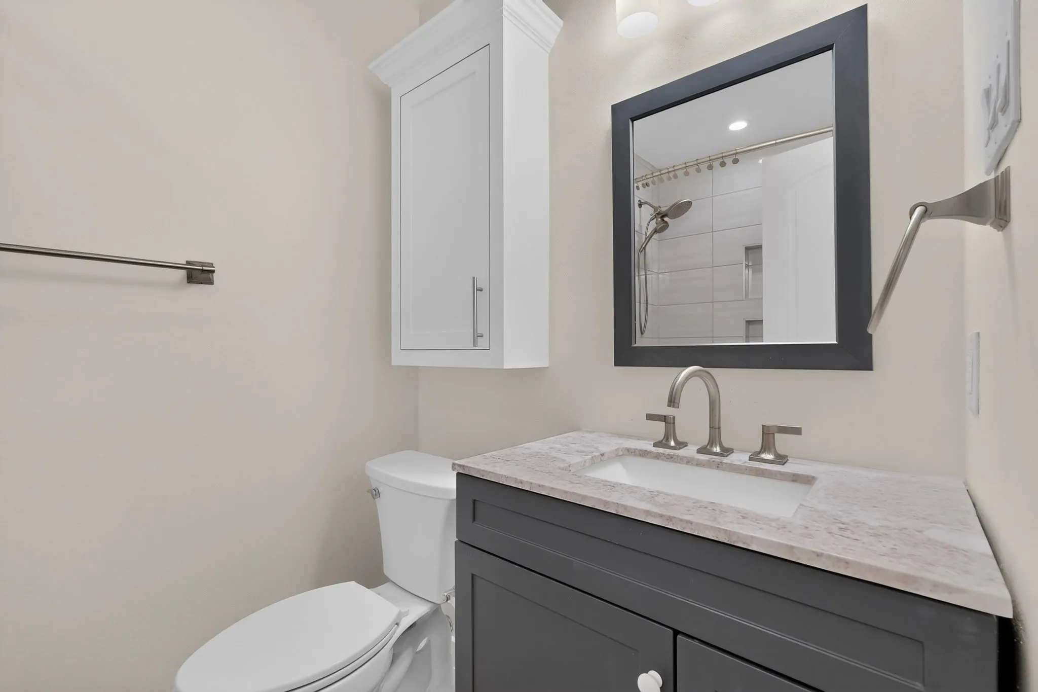 Vanity with integrated sink, dark wood-finish cabinetry, and stone countertop