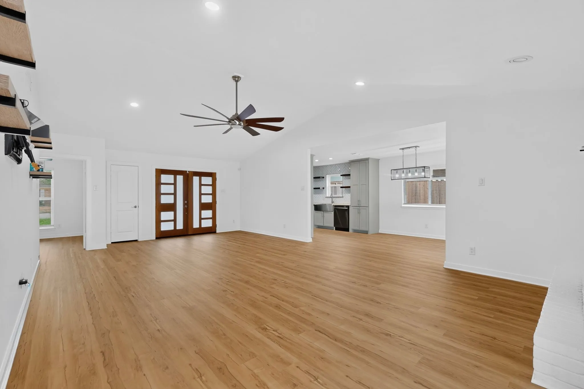 Vaulted ceilings, recessed lighting, wood-finish flooring, ceiling fan, and double entry doors