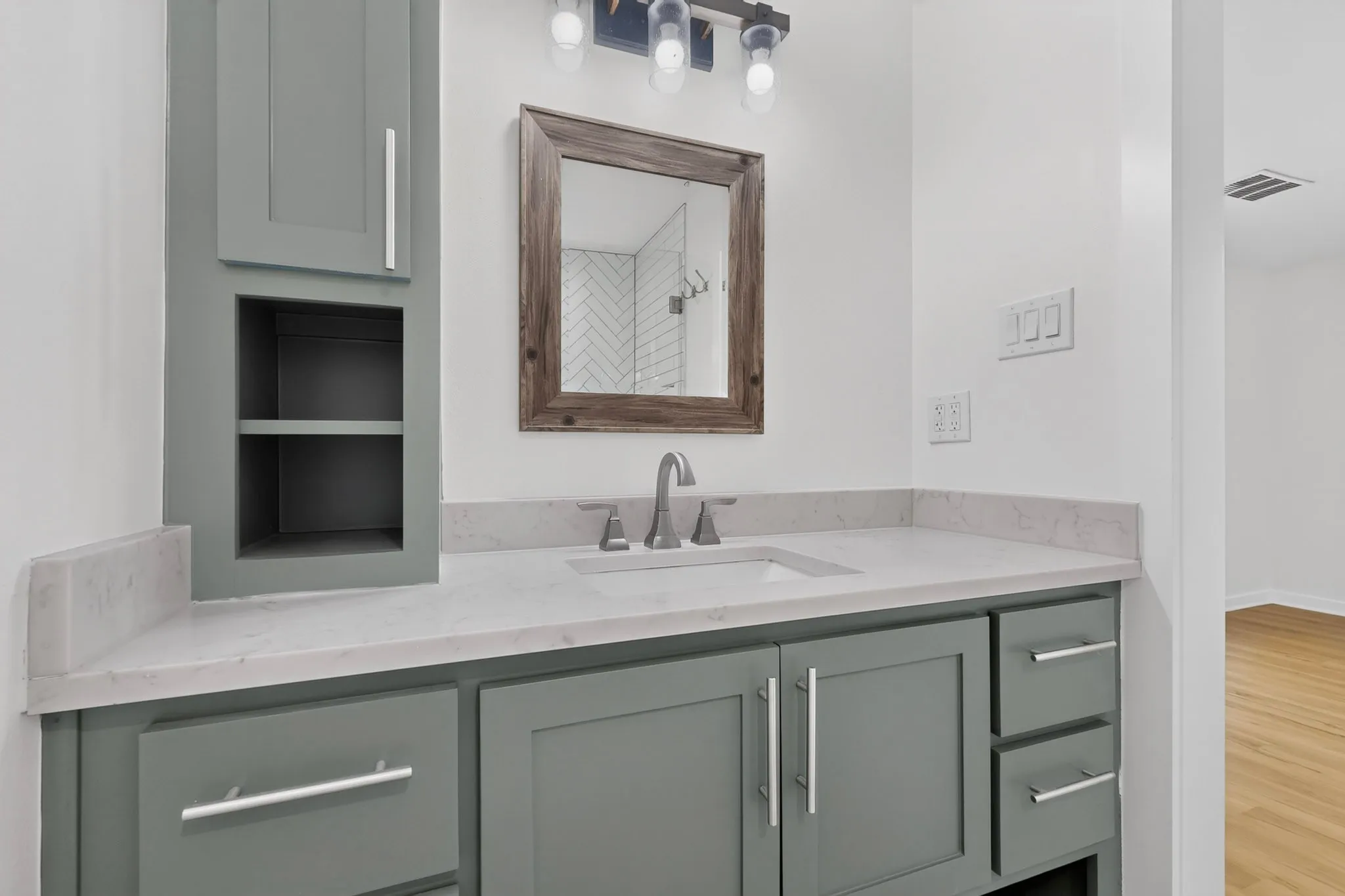 Contemporary vanity with gray cabinetry, integrated sink, and light-toned countertop