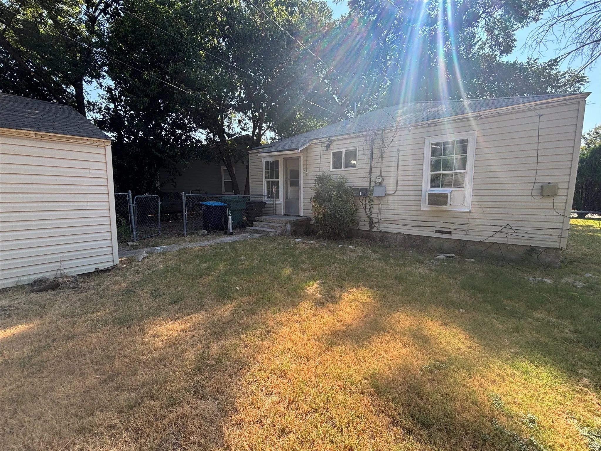 Siding exterior with multiple windows, accompanied by a detached shed with complementary siding