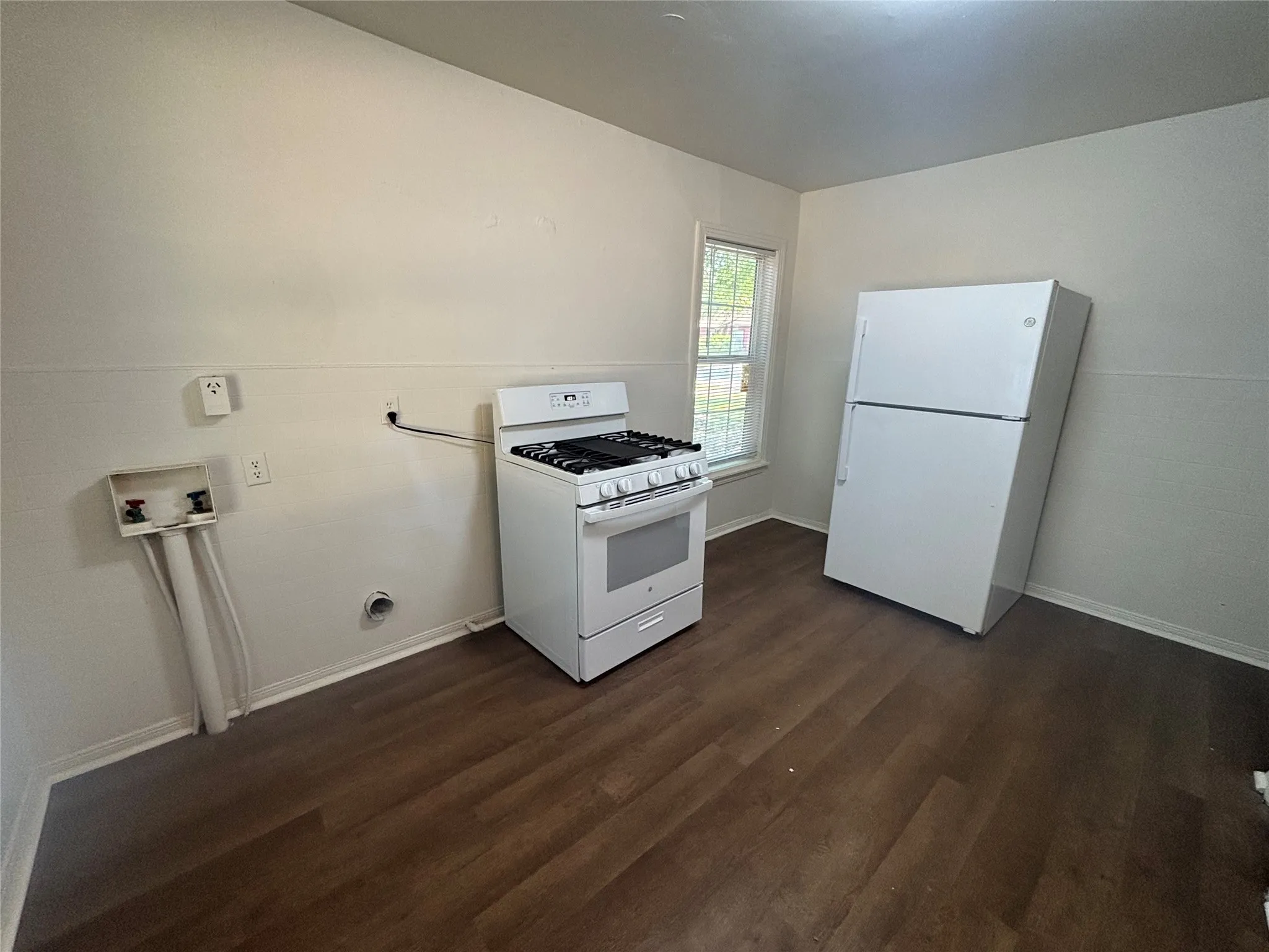 Wood-finish flooring, white walls, and a window providing natural light