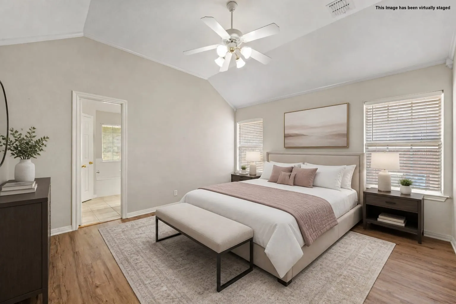 Vaulted ceiling featuring a ceiling fan, wood-finish flooring, and multiple windows with blinds