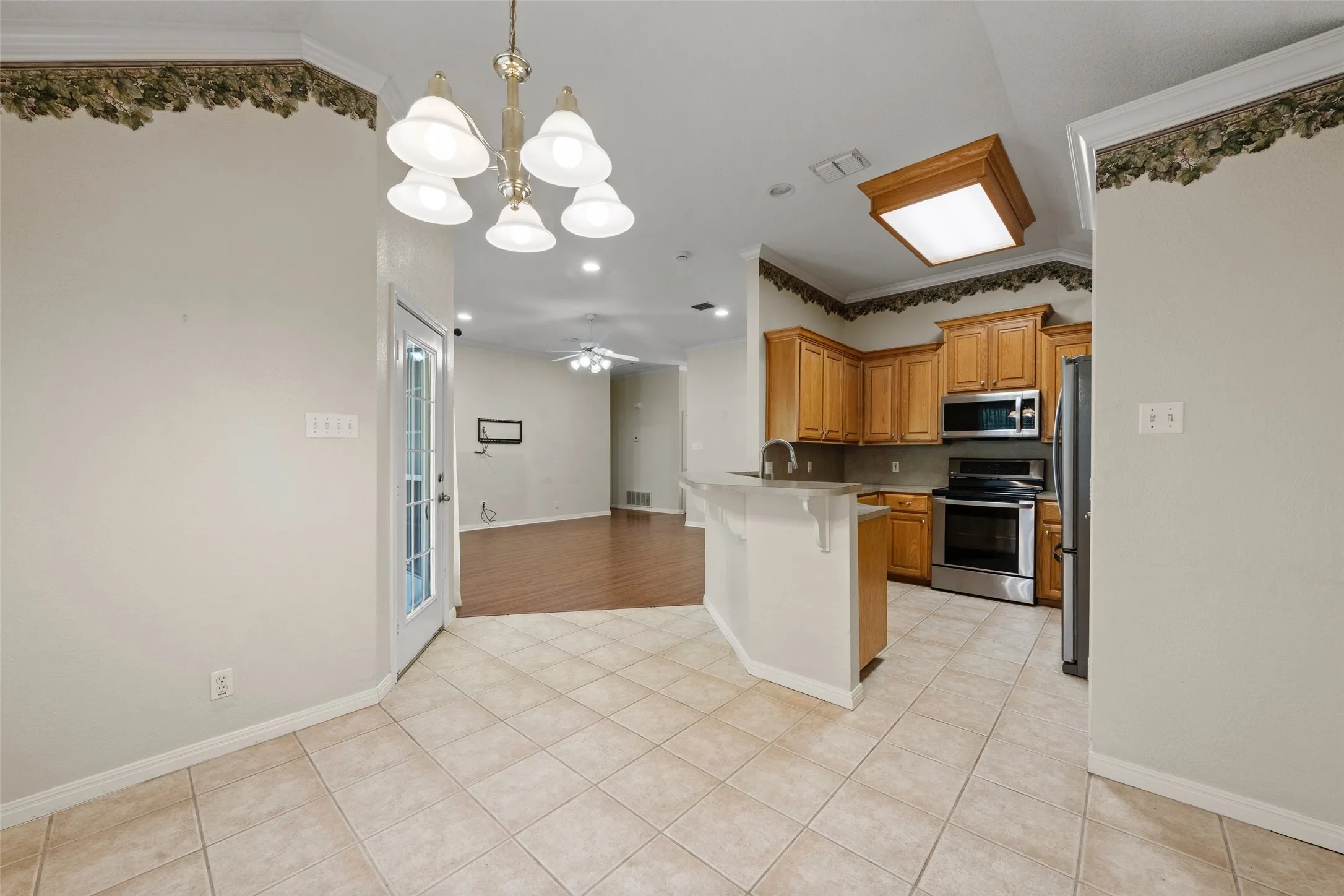 Kitchen featuring wood cabinetry, stainless steel appliances, and a breakfast bar
