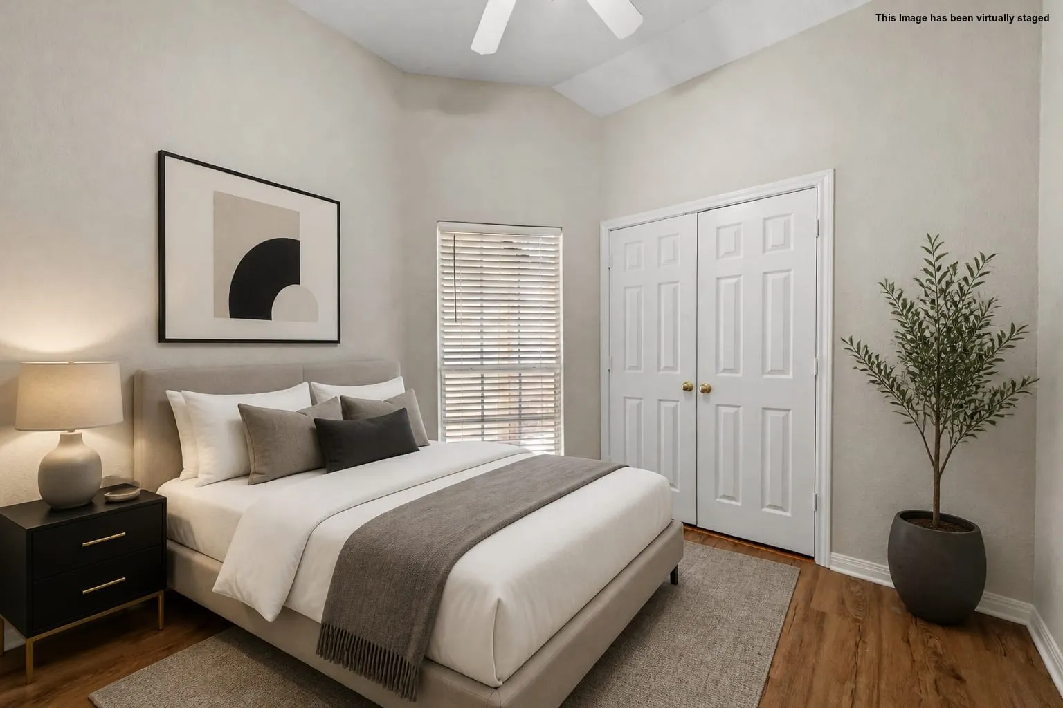Vaulted ceiling with ceiling fan, wood-finish flooring, window with blinds, and bi-fold closet doors