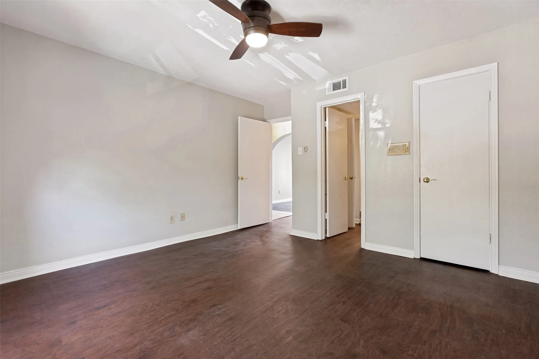Wood-finish flooring with a ceiling fan light fixture