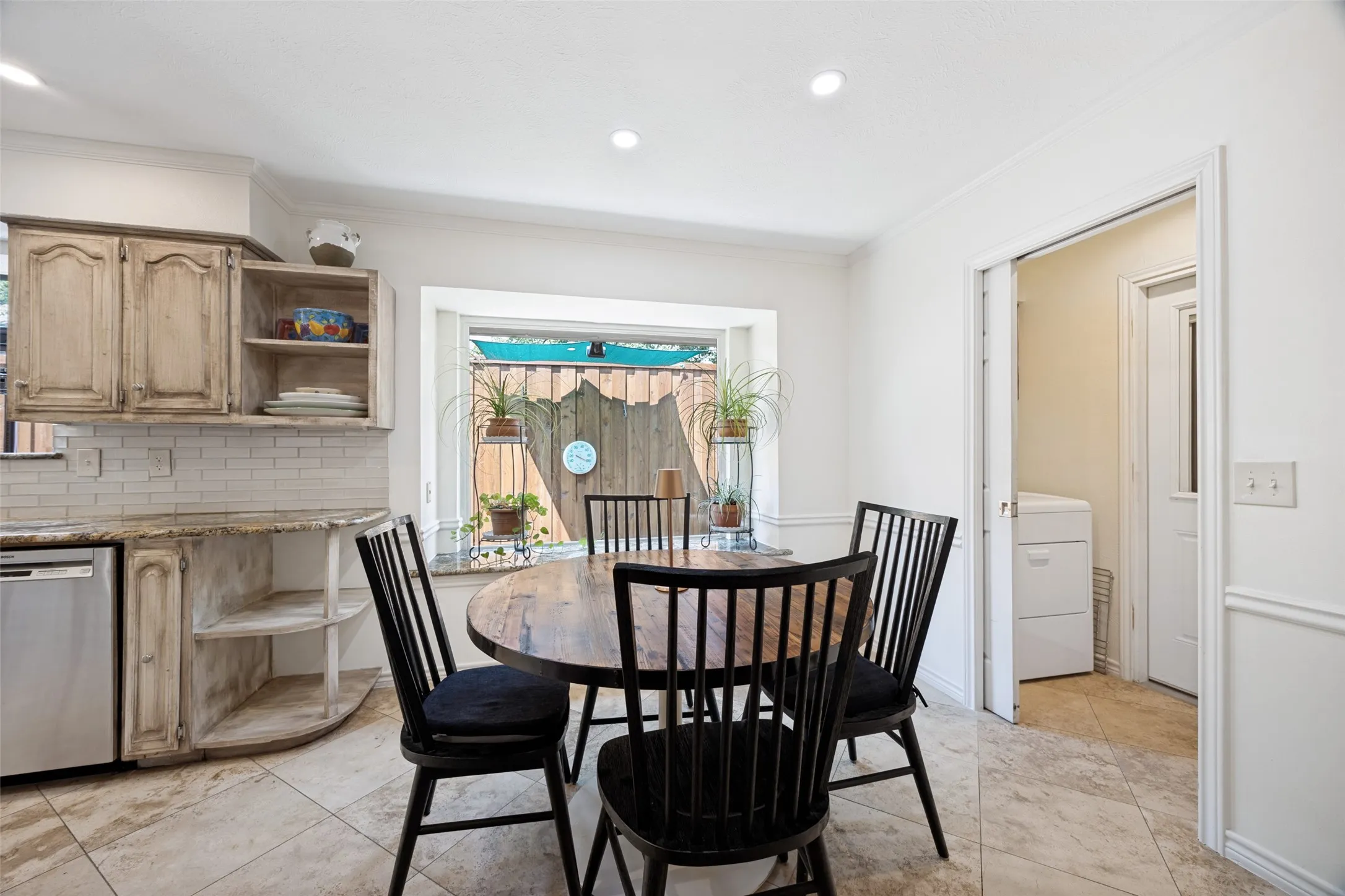 The breakfast area features a large picture window and granite clad window seat. Pocket door encloses the utility area