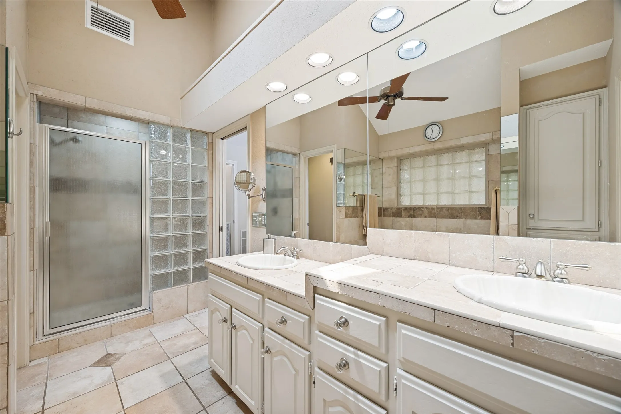 Lots of storage, dual height individual vanities and stand alone shower in the primary bath