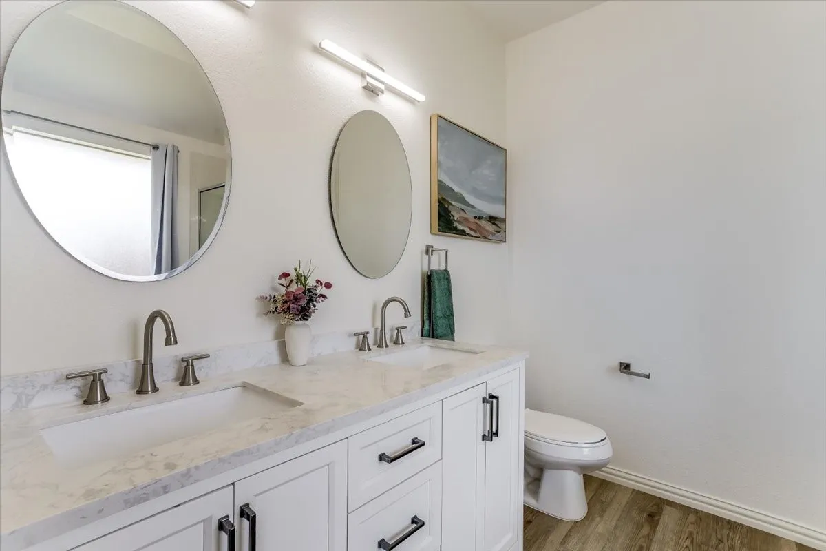 Dual vanity with undermount sinks, stone-finish countertop, and brushed nickel fixtures