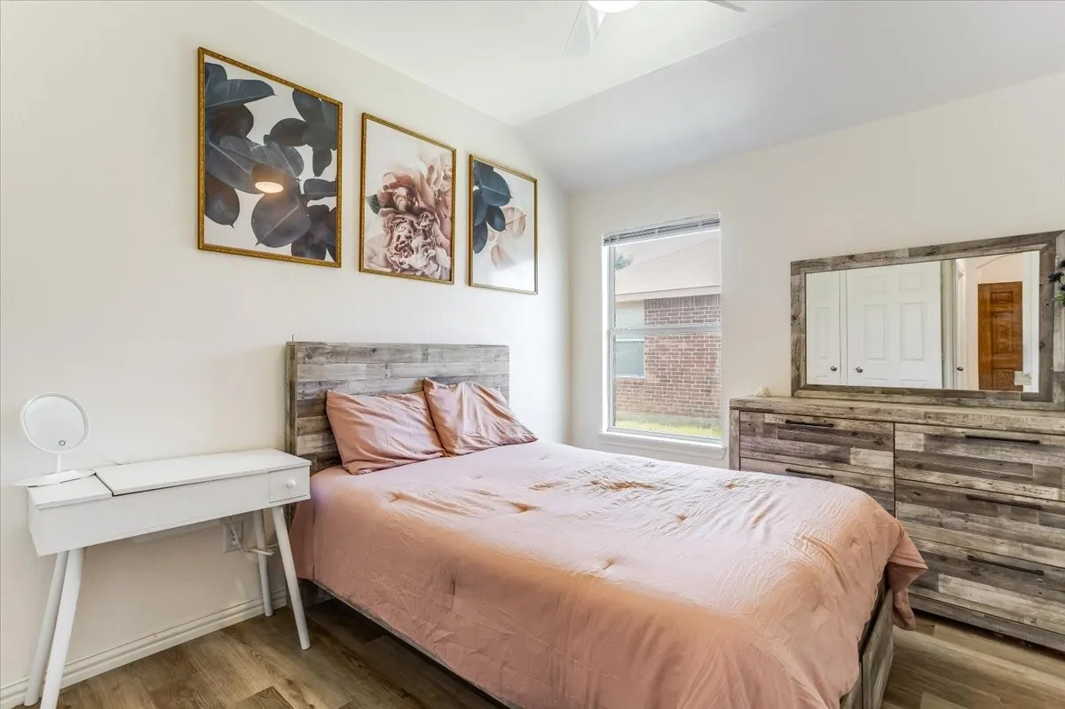 Wood-finish flooring with crisp white walls and a large window