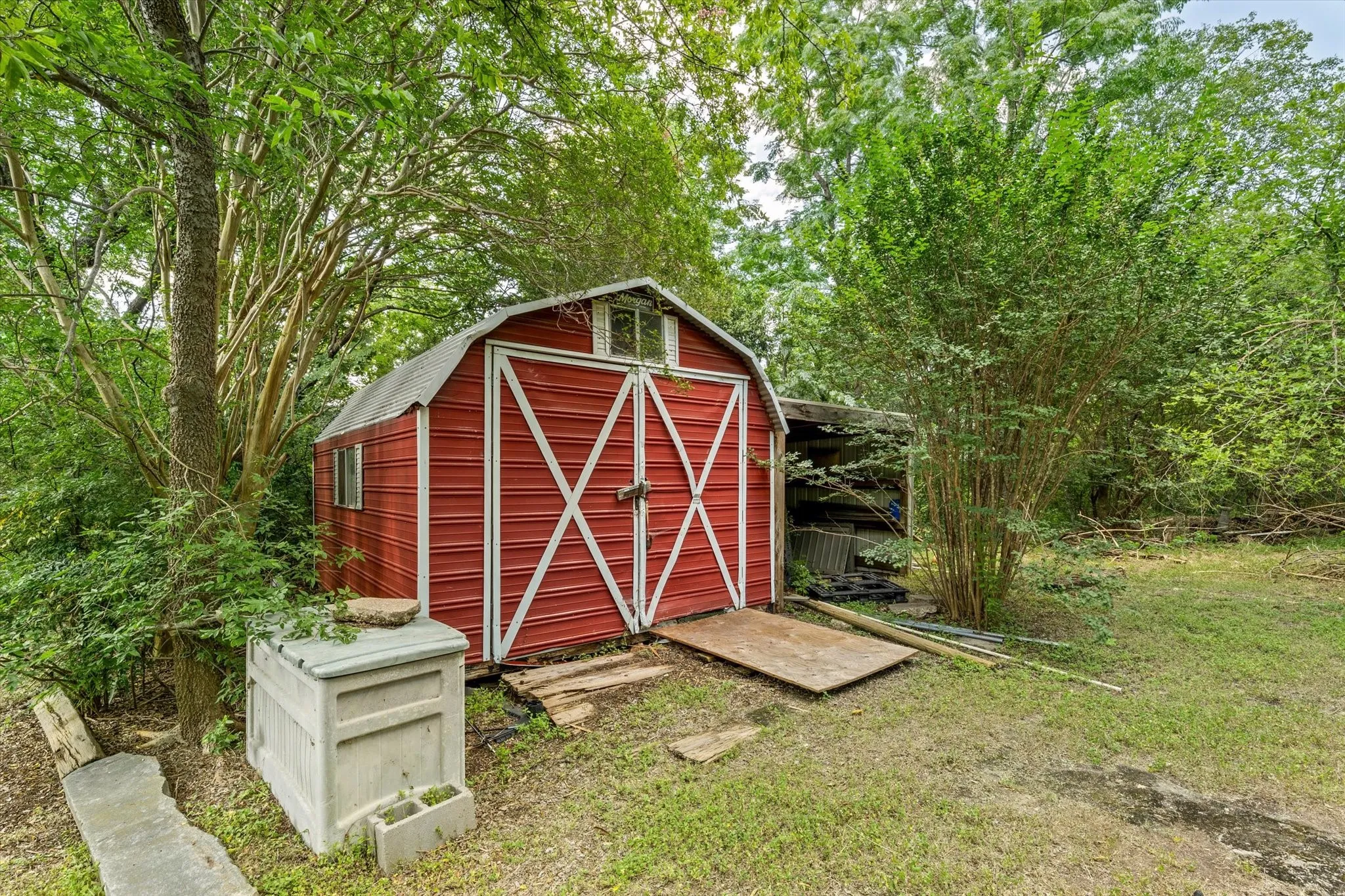 Red barn-style shed with white trim and double doors